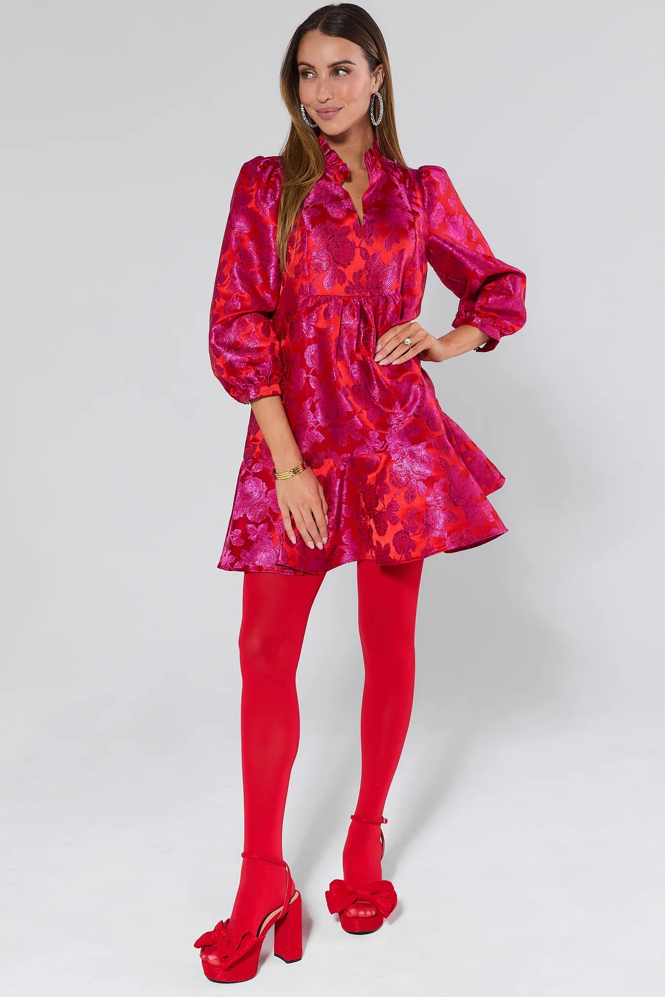 Woman wearing a vibrant Alyssa Brocade Drop Waist Dress against a white background