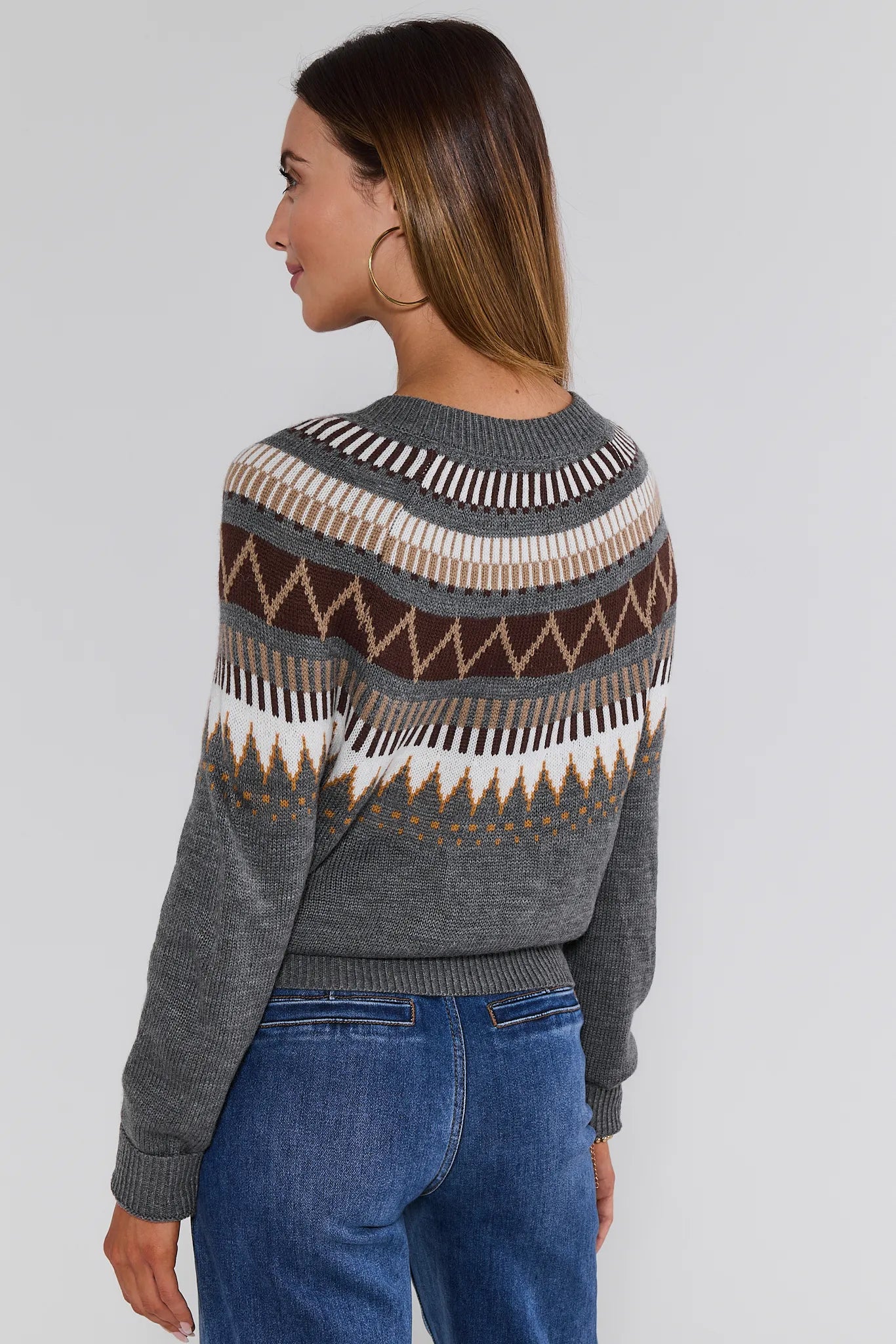 Woman wearing a gray Alyssa Cardigan with a patterned design on a plain background