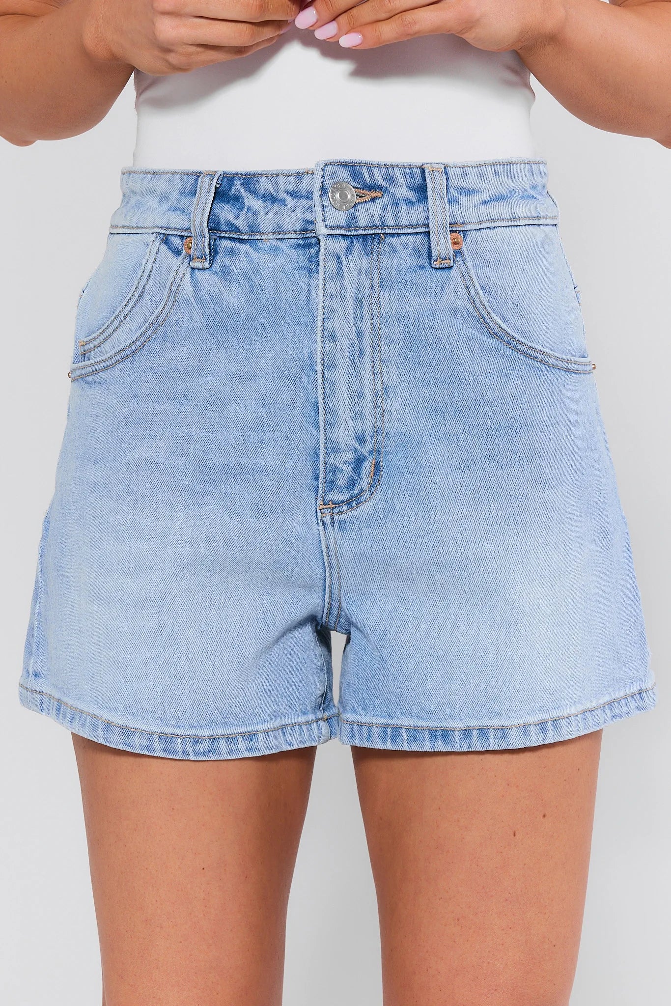 Light blue denim shorts worn by a person on a plain background