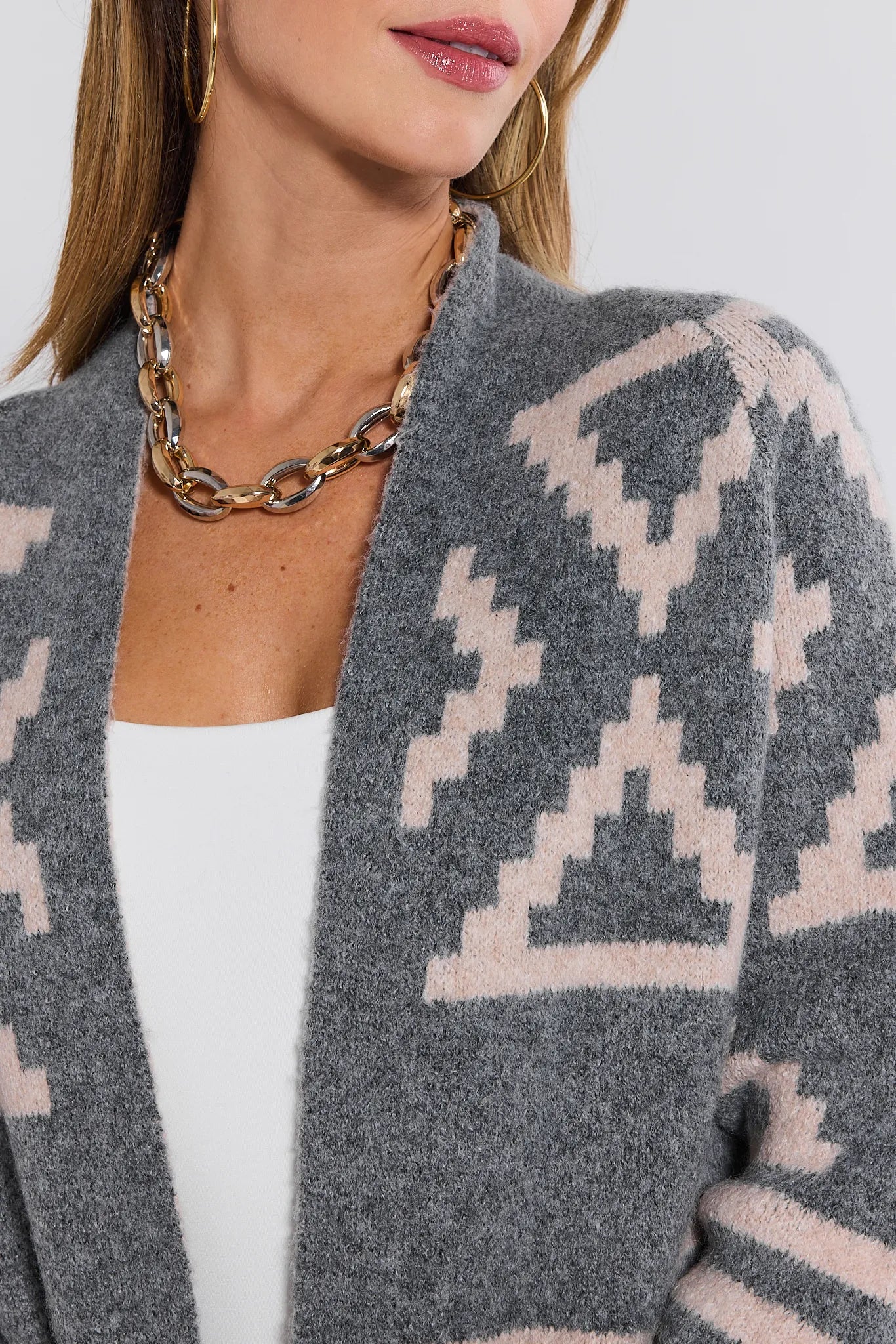 Gray patterned Helena Cardigan worn by a person with a white top underneath, on a light gray background.