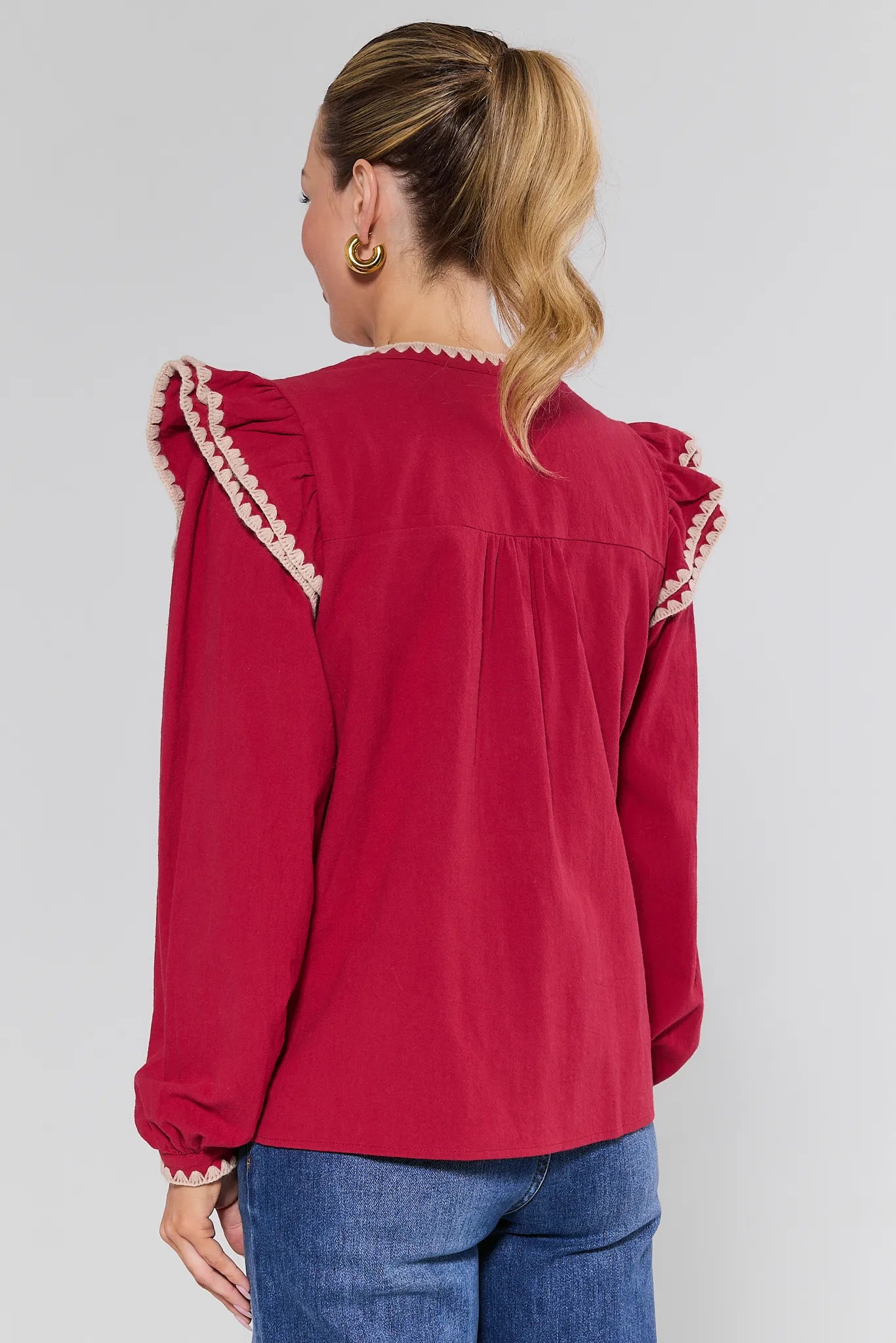 Red Viviana Top with ruffled sleeves worn by a person on a plain background