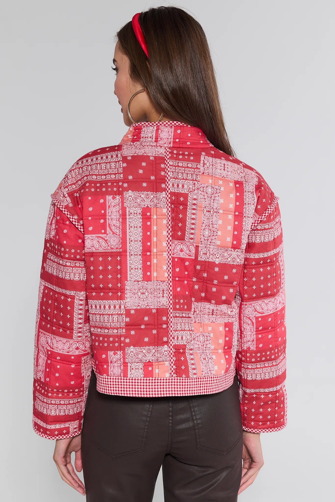 Woman wearing a red patterned Cassidy Jacket on a white background