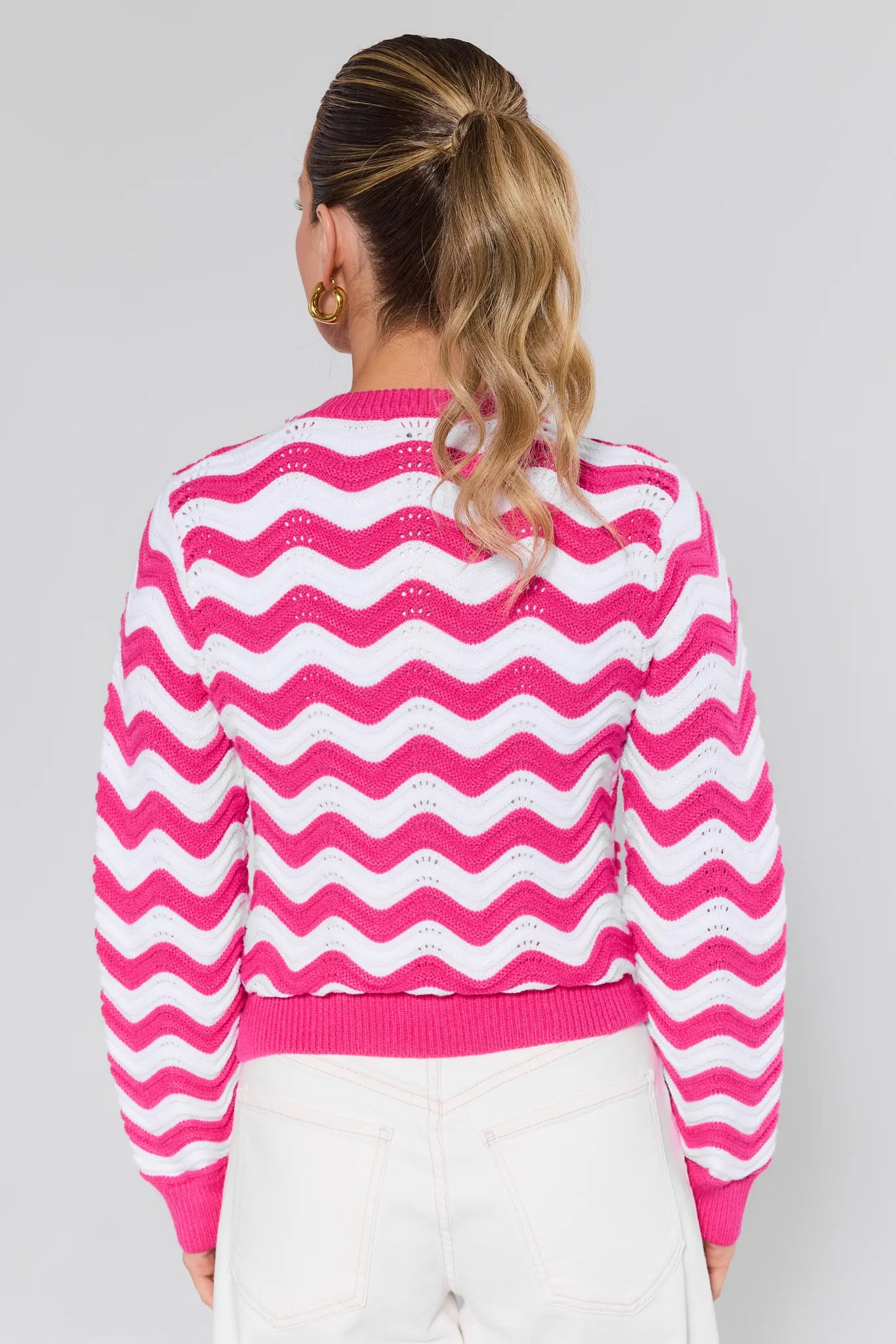 Woman wearing a Eliana Pink Chevron Knit Sweater against a plain background