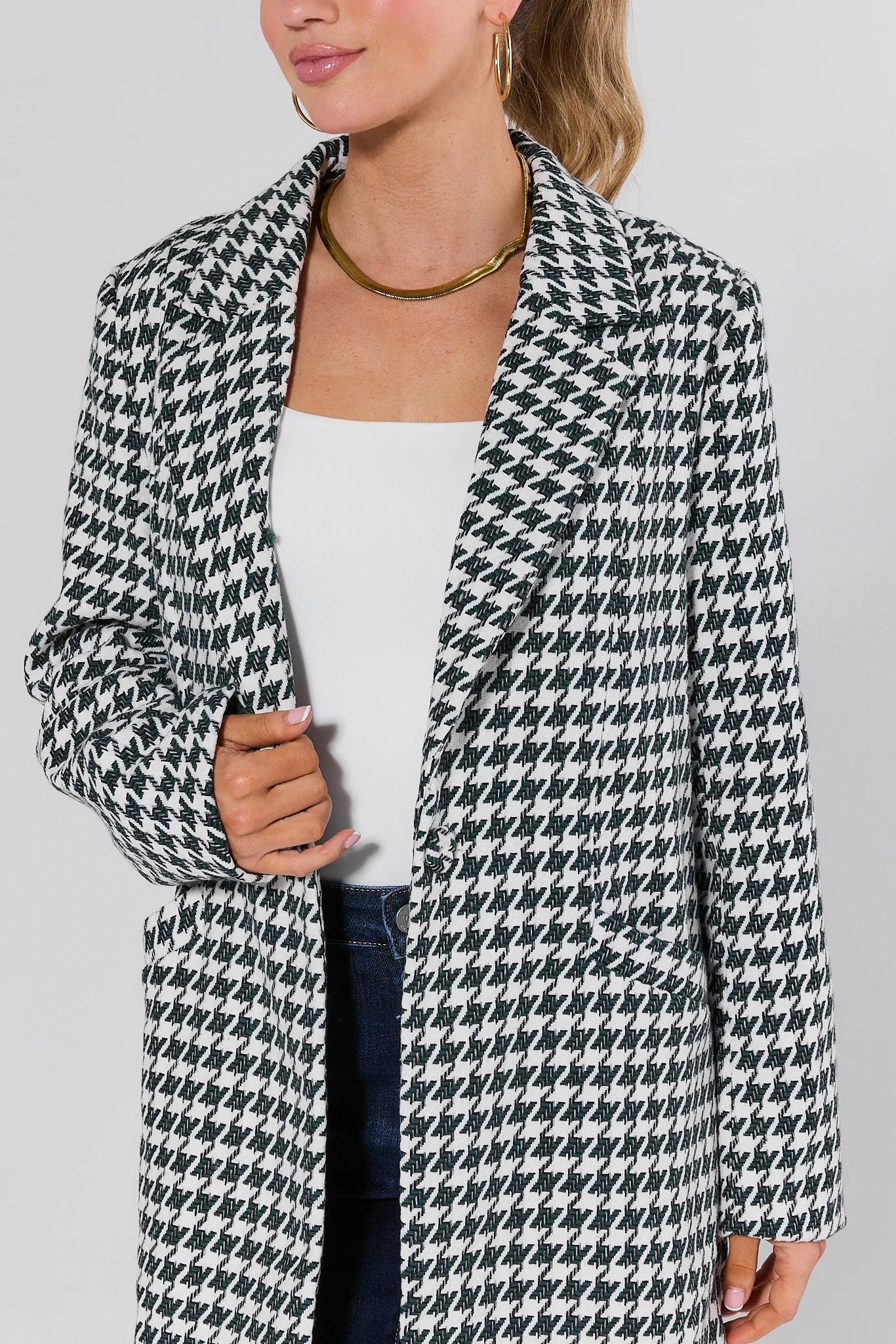 Woman wearing a Jonah Green Houndstooth Coat on a plain background