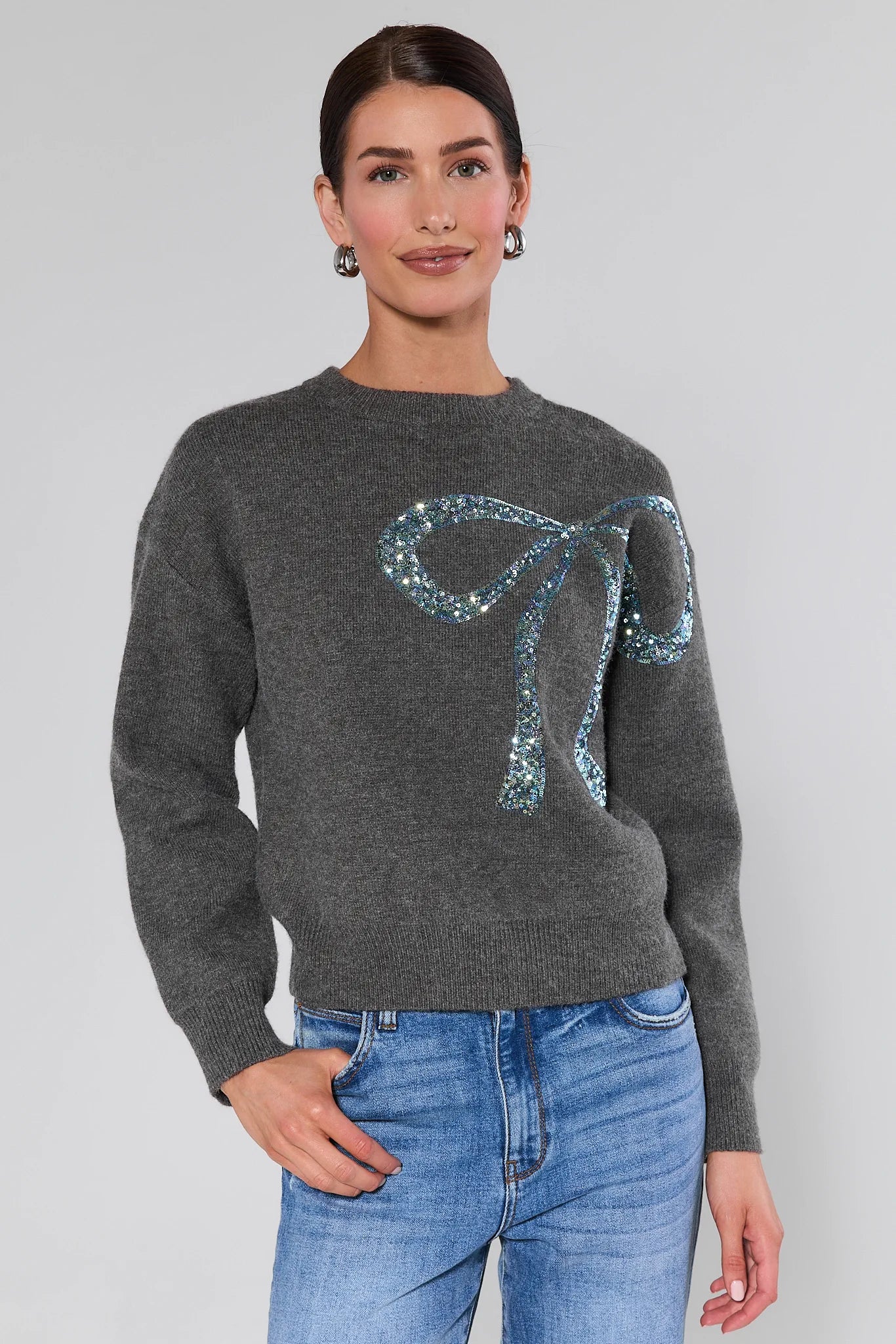 Woman wearing a Stella Grey Embellished Sweater on a plain background