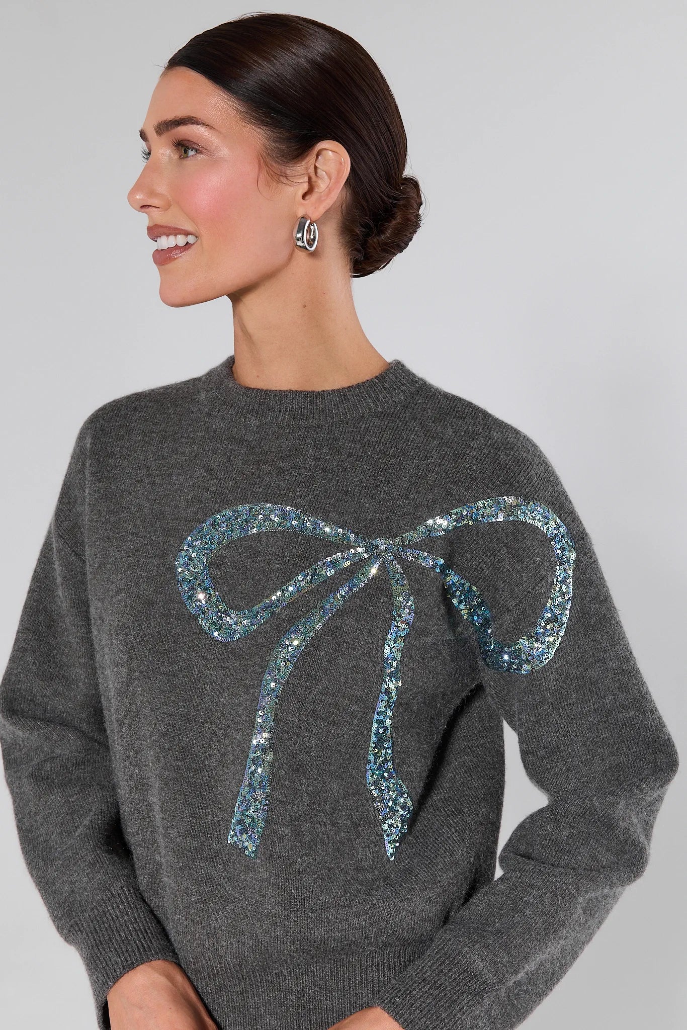 Woman wearing a Stella Grey Embellished Sweater on a plain background
