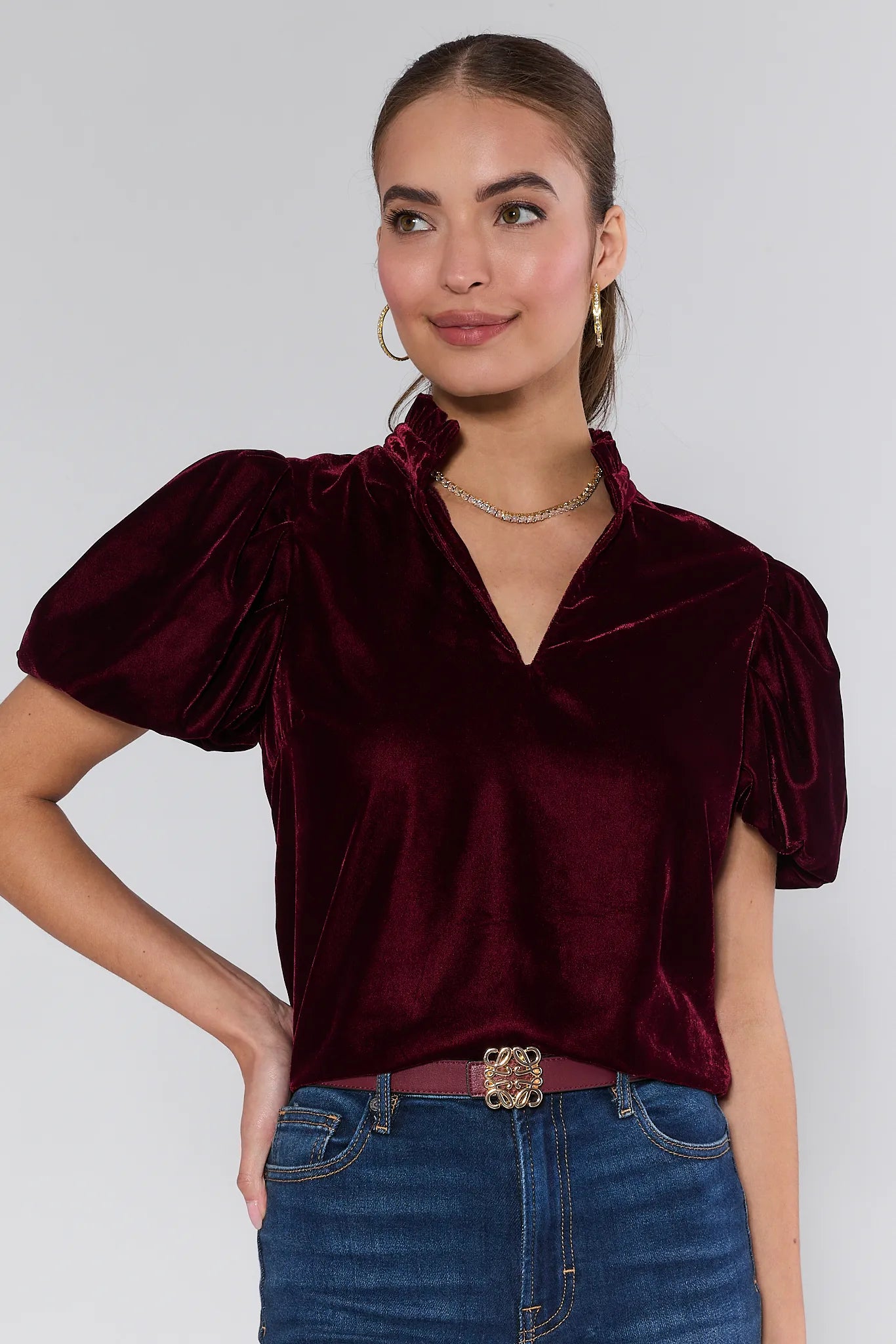 Woman wearing a Lynette Cranberry Velvet Puff Sleeve Top against a plain background