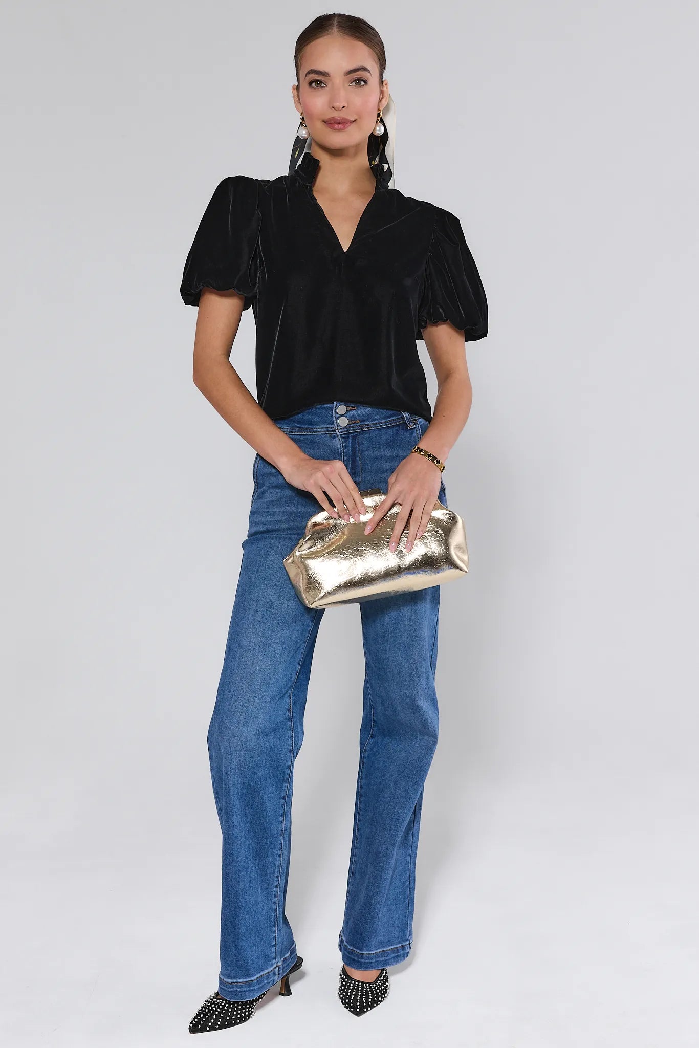 Woman wearing a Lynette Black Velvet Puff Sleeve Top against a plain background