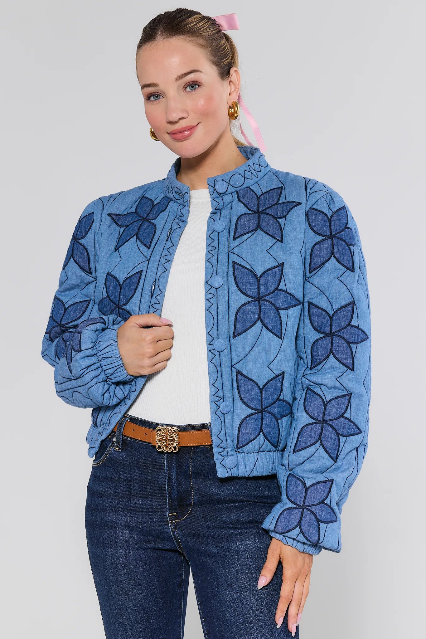 Woman wearing a blue floral-patterned Krista Jacket on a plain background