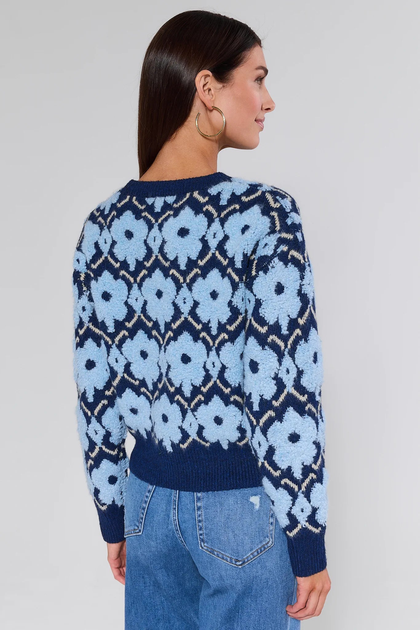 Woman wearing a Brynn Blue Floral Knit Sweater against a white background