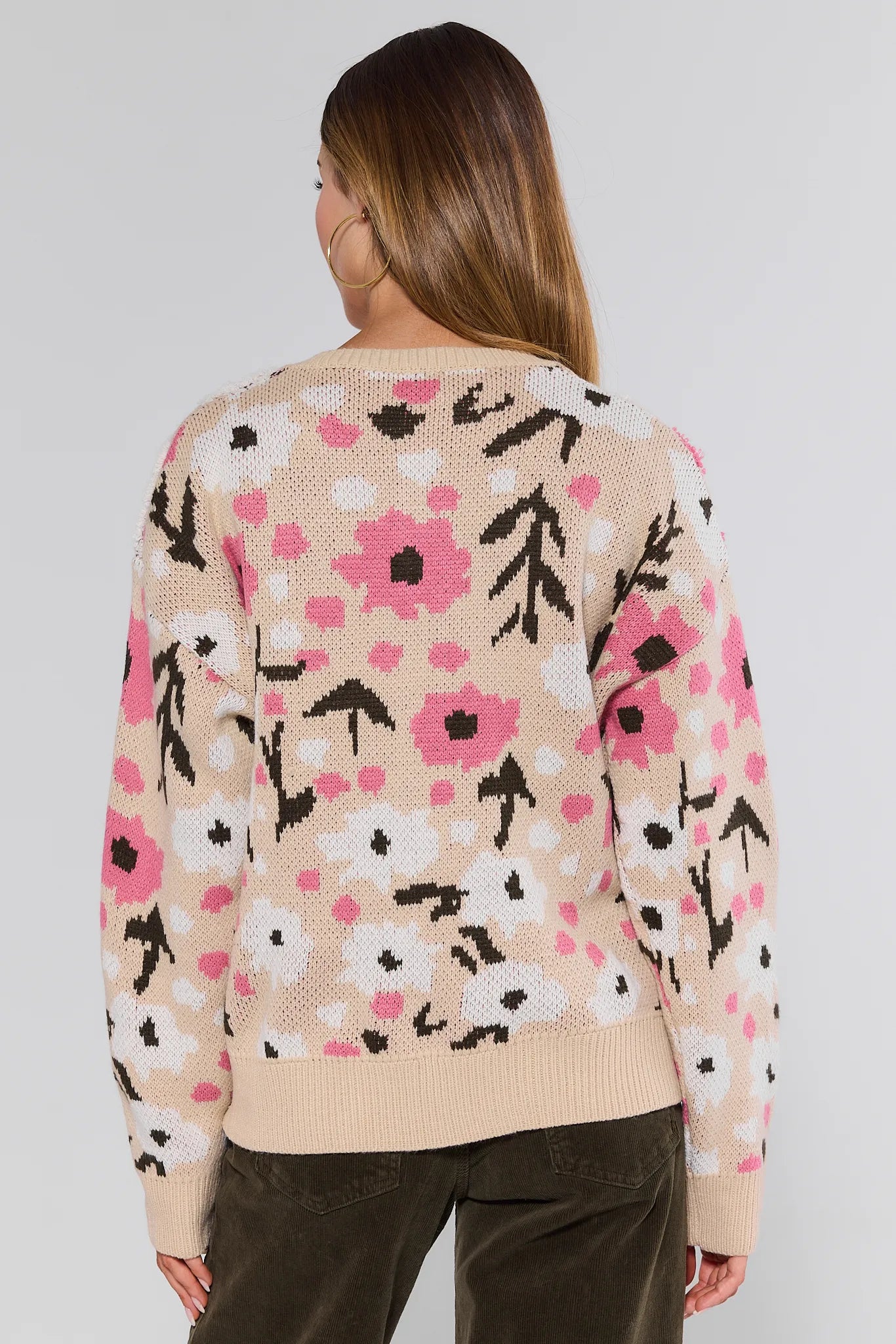 Woman wearing a floral patterned Norah Cardigan on a plain background