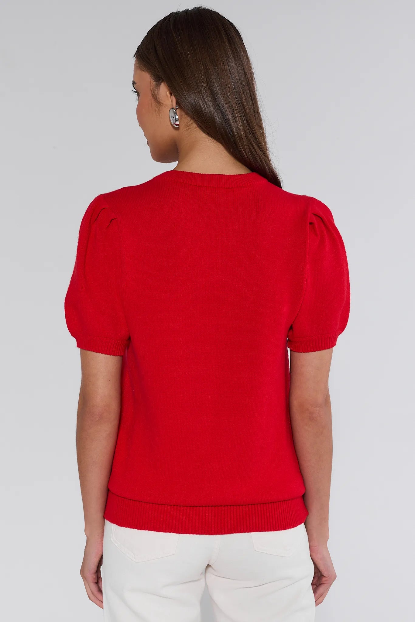 Woman wearing a red sweater with 'cheers' text on a plain background