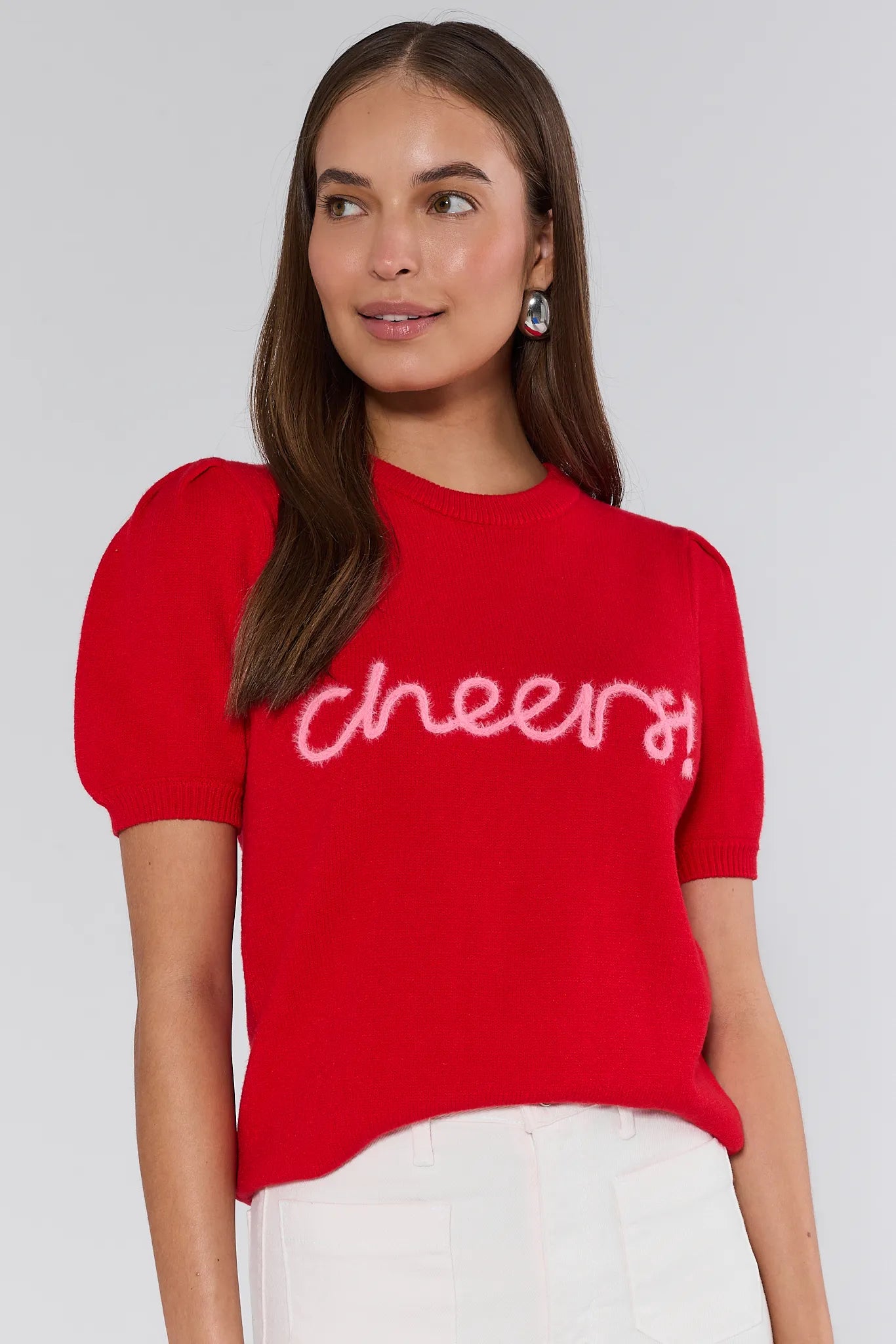Woman wearing a red sweater with 'cheers' text on a plain background