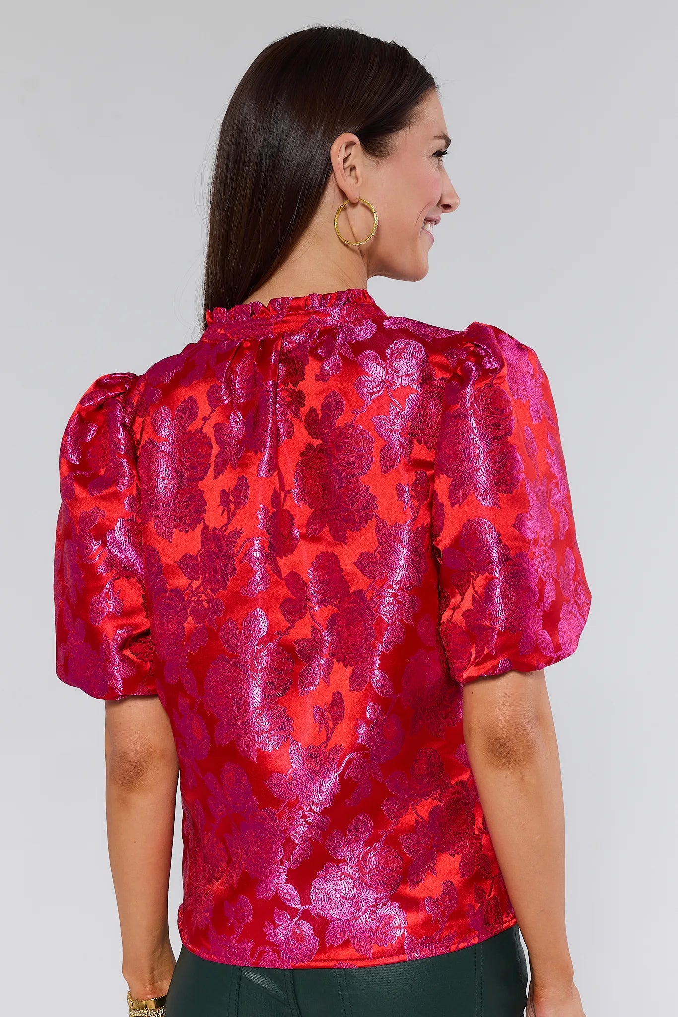 Woman wearing a red Alyssa Brocade Puff Sleeve Top against a gray background