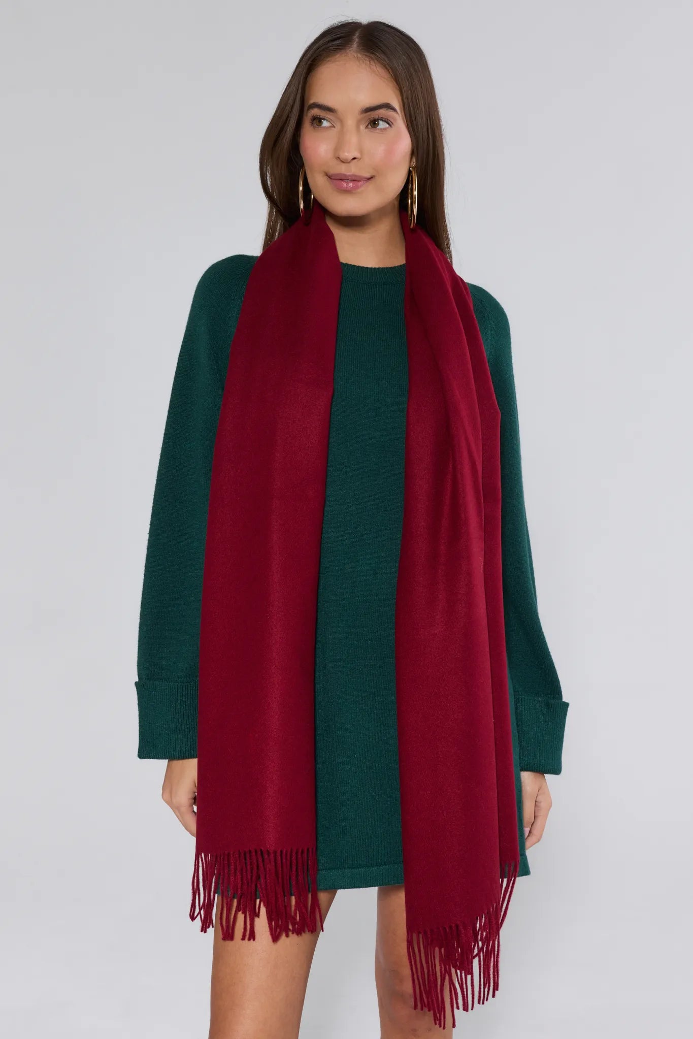 Woman wearing a green dress and red scarf on a white background