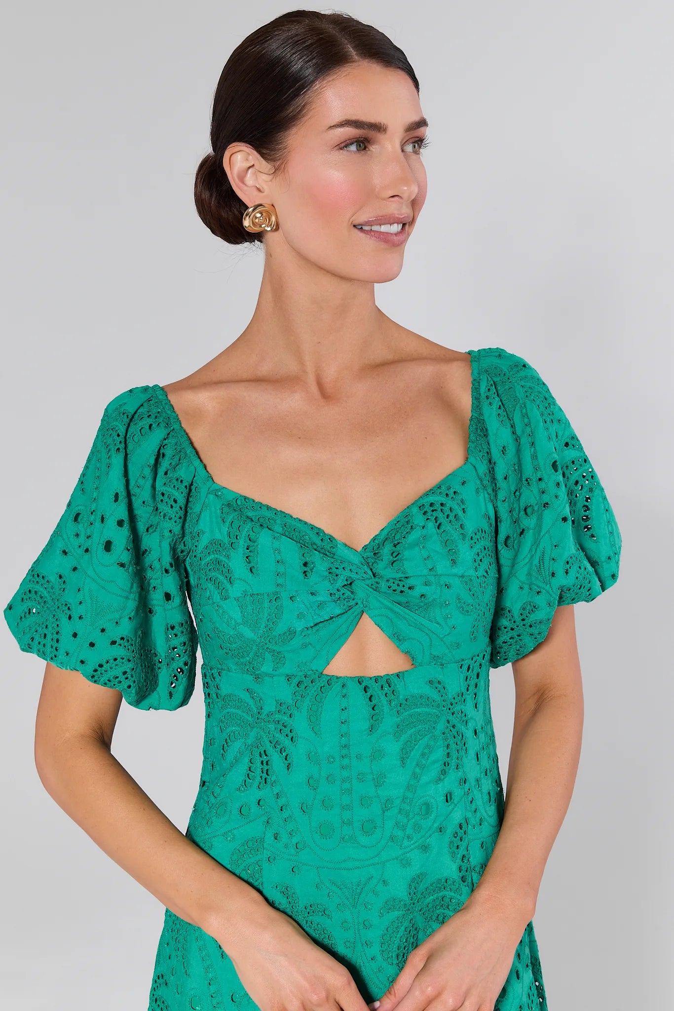 Close up of a woman wearing a Sydney Green Eyelet Dress against a gray background