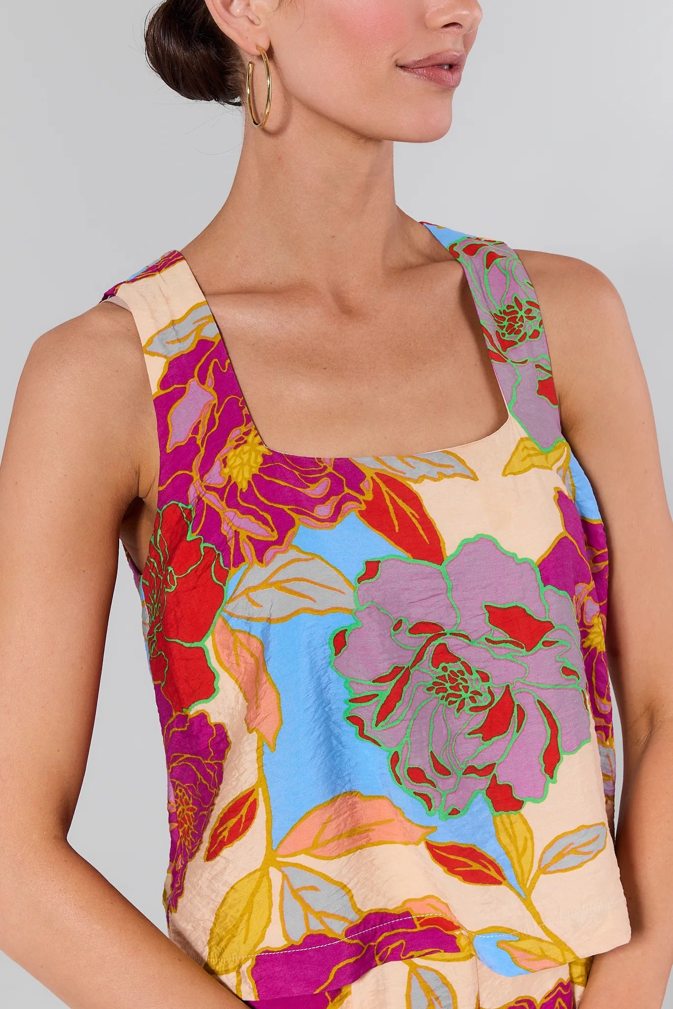 Close up of a woman wearing a Marisol Multicolor Floral Tank Top against a plain background