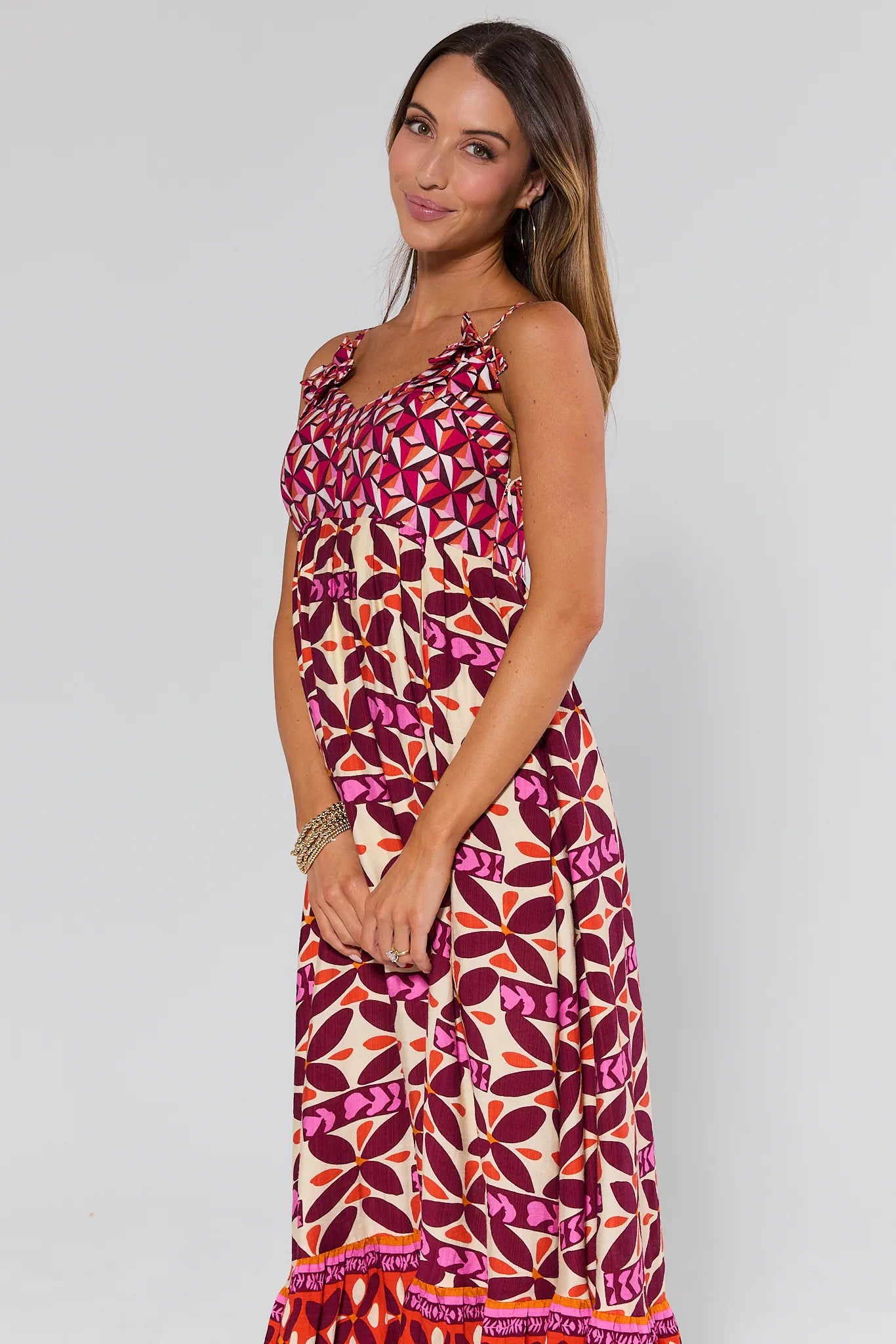 Woman wearing a Jackie Pink Printed Midi Dress on a plain background