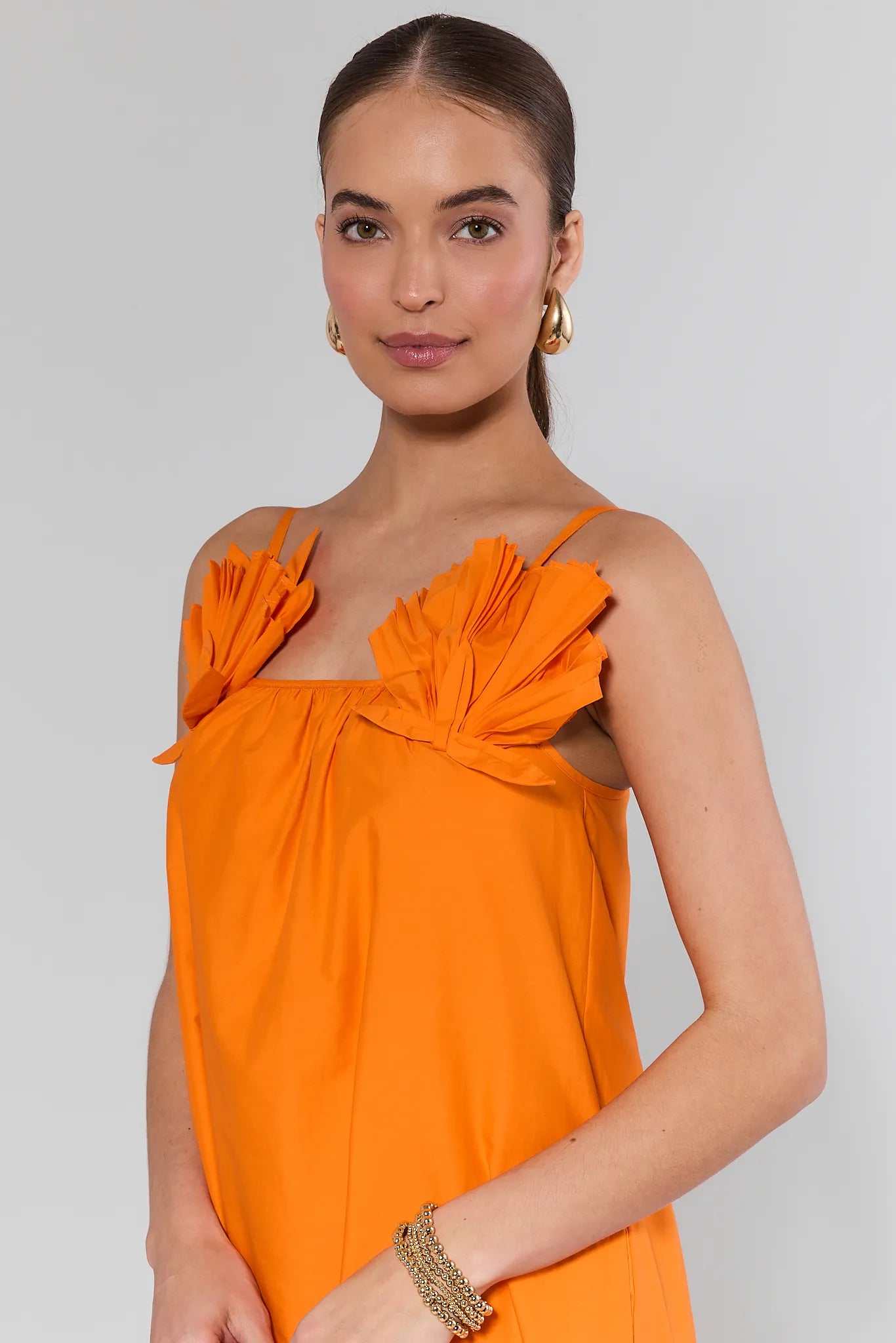 Woman wearing an Ariel Orange Shell Midi Dress with a plain background