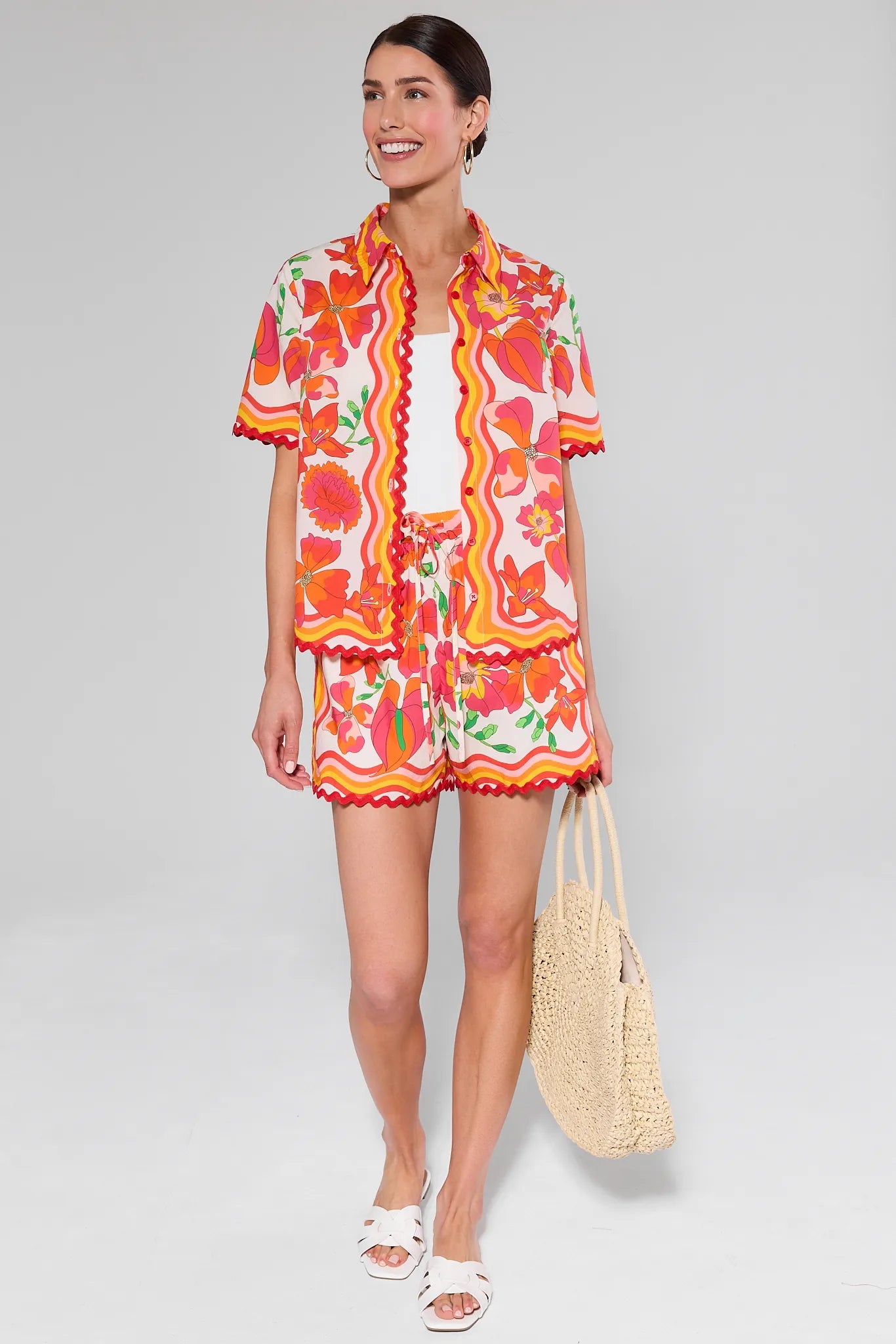 Woman wearing a Melissa Orange Printed Button Up Top with a white background