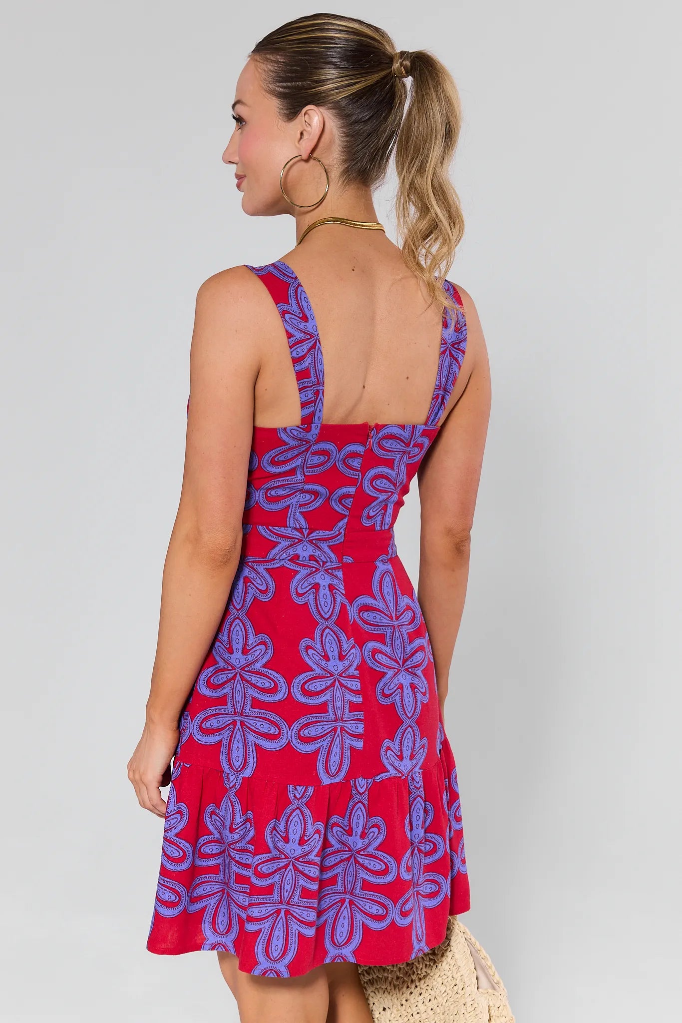 Woman wearing a Clarissa Multi Printed Mini Dress and earrings against a plain background