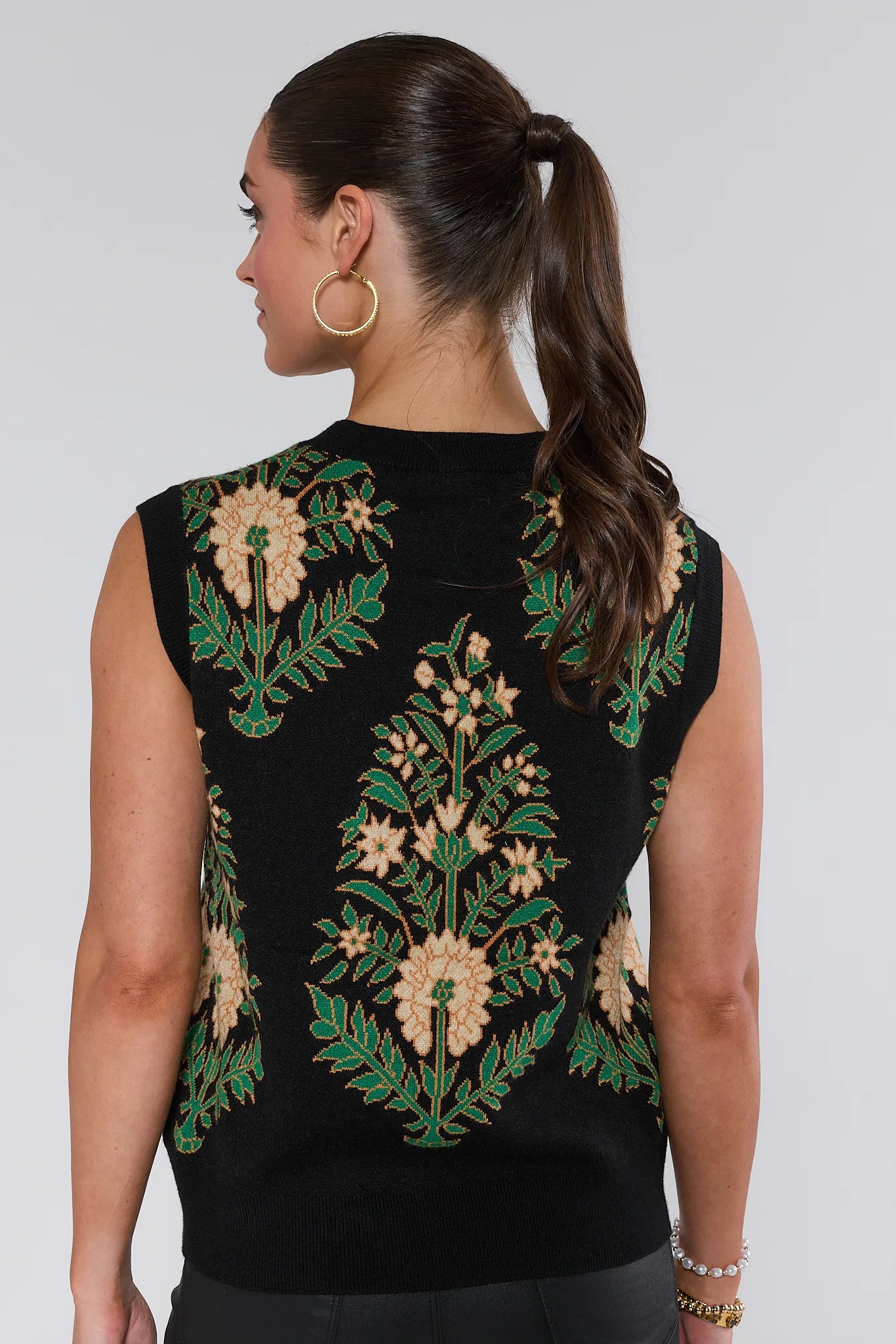 Black sleeveless Edie Sweater with floral embroidery on a plain background