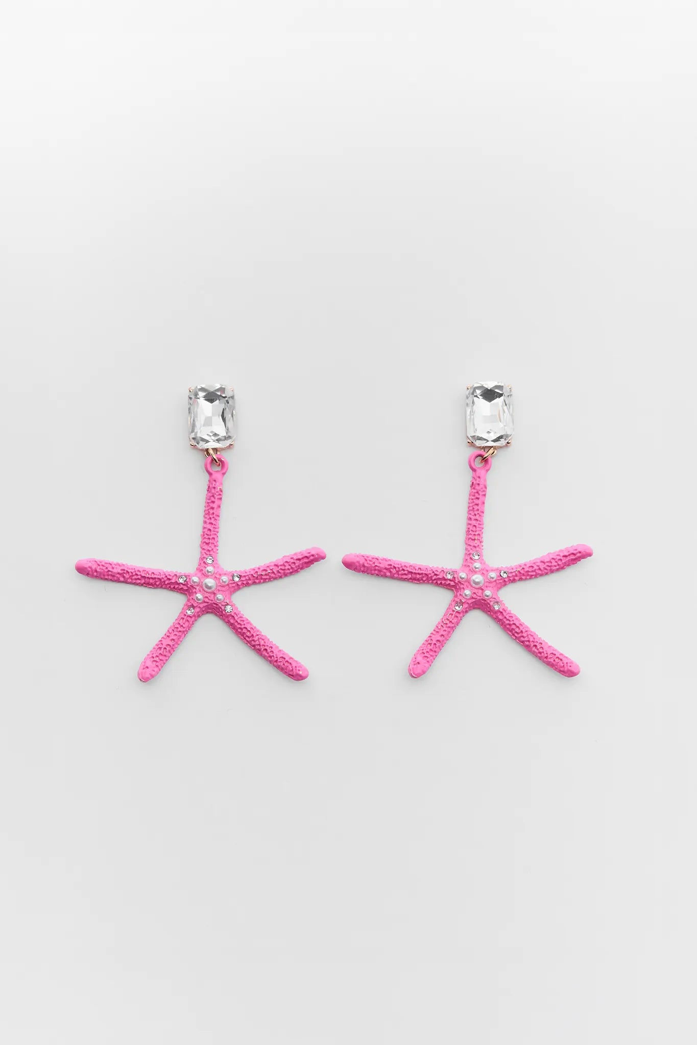 Cora Pink Starfish Earrings with clear gemstones on a light gray background