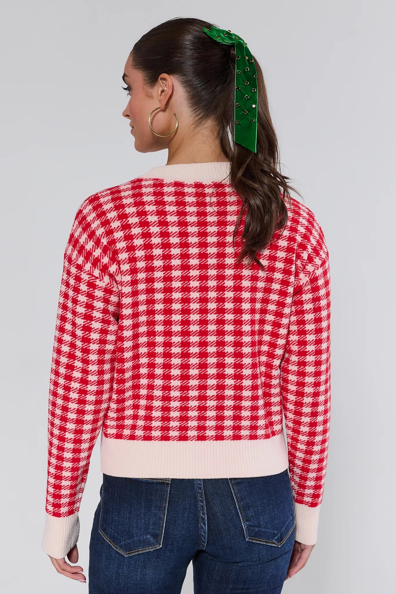 Person wearing a red and white checkered sweater with a plain background