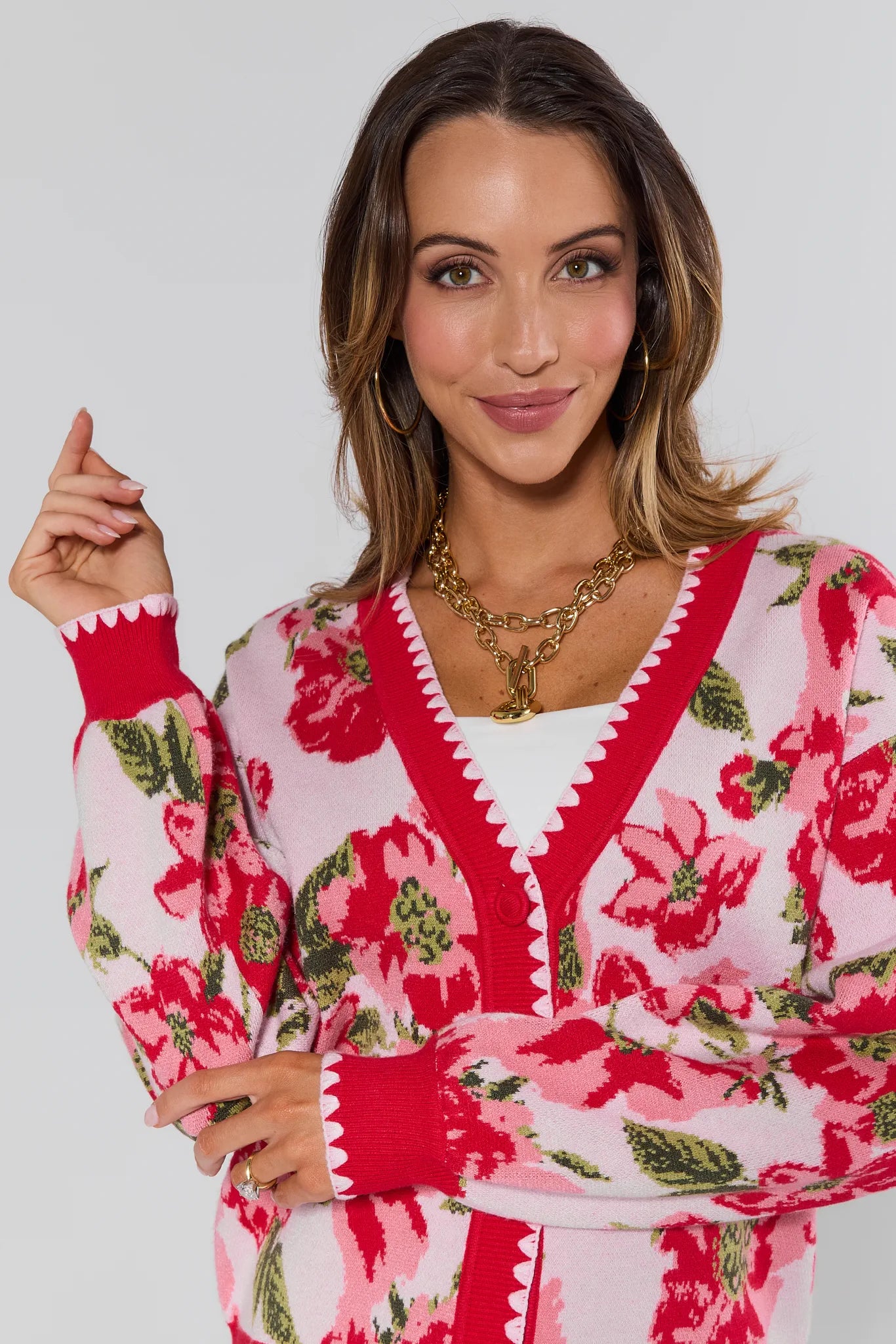 Woman wearing a red and white floral dress with a plain background