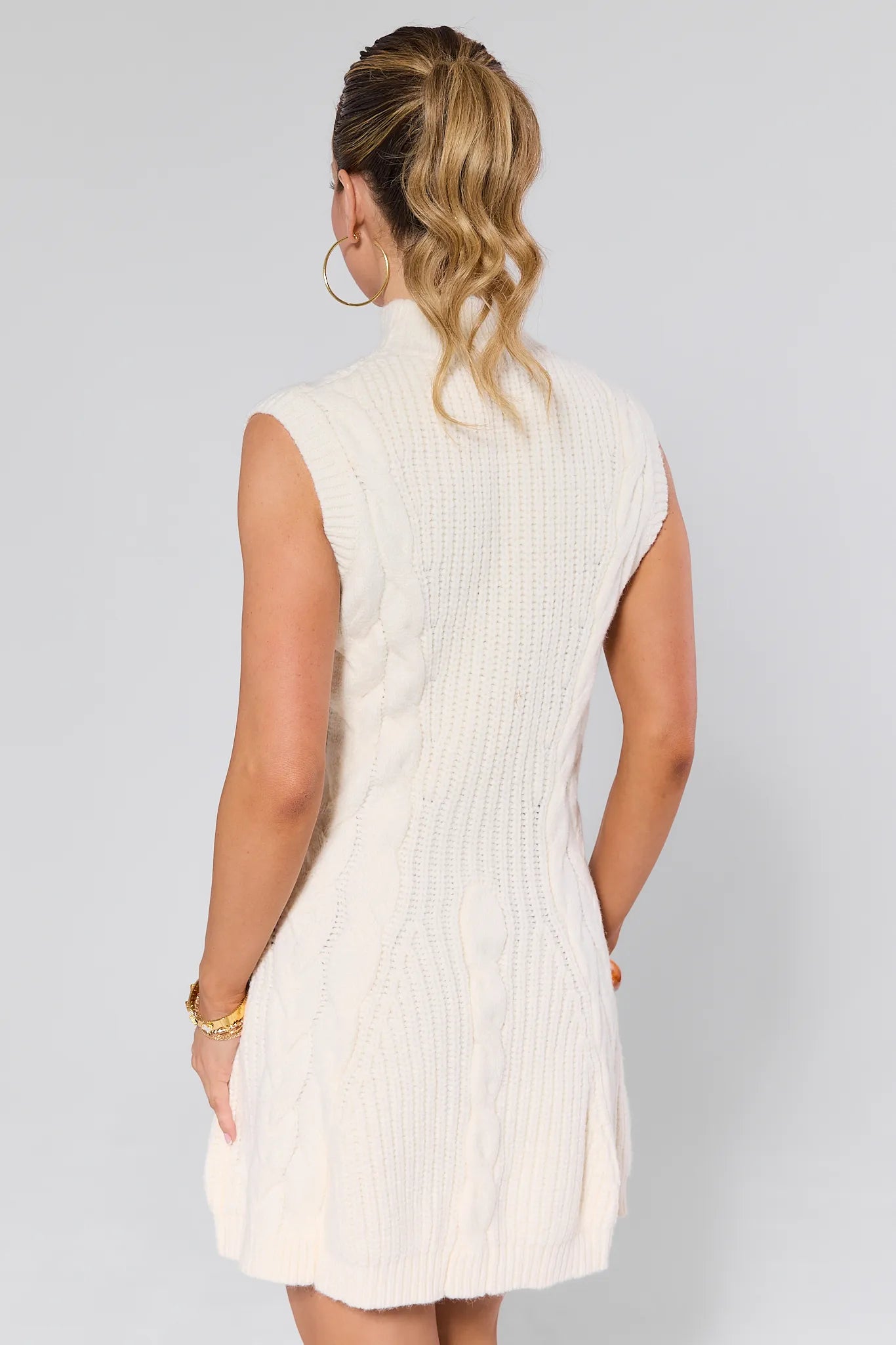 Woman wearing a Mila Ivory Knit Sweater Dress against a plain background