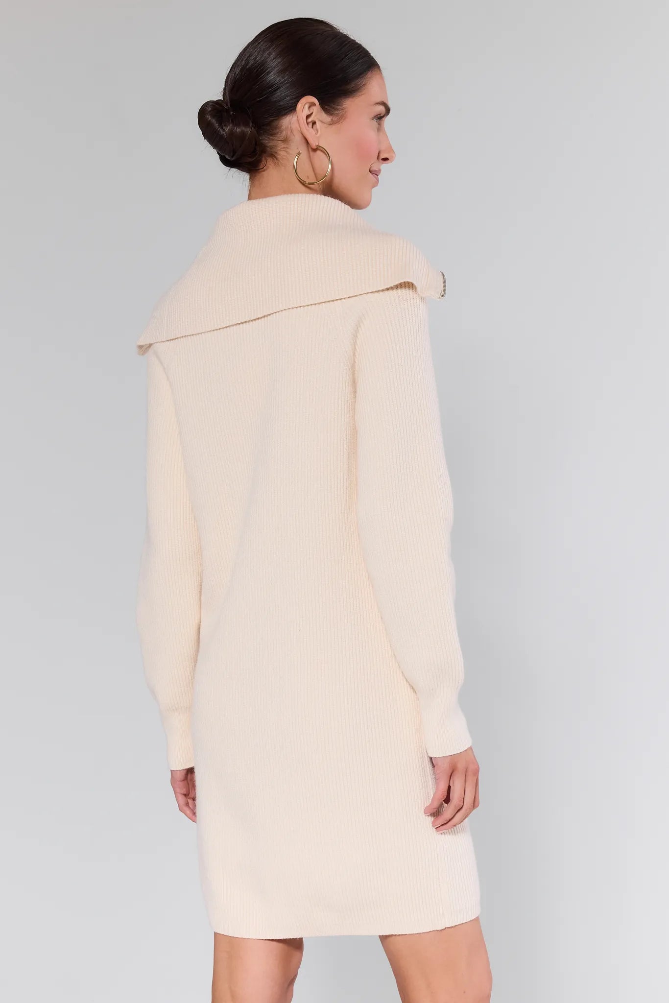 Woman wearing a Aubrey Ribbed Knit Sweater Dress with a zipper detail on a plain background