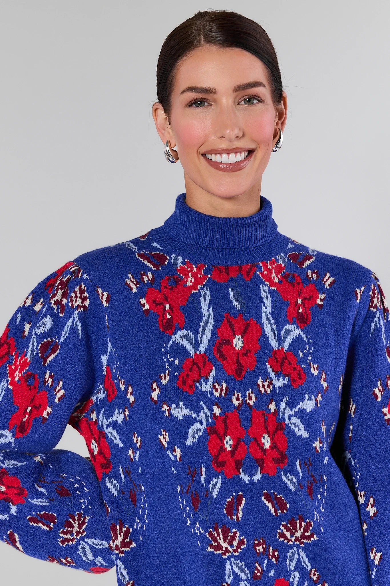 Woman wearing a Loretta Blue Floral Knit Sweater on a plain background