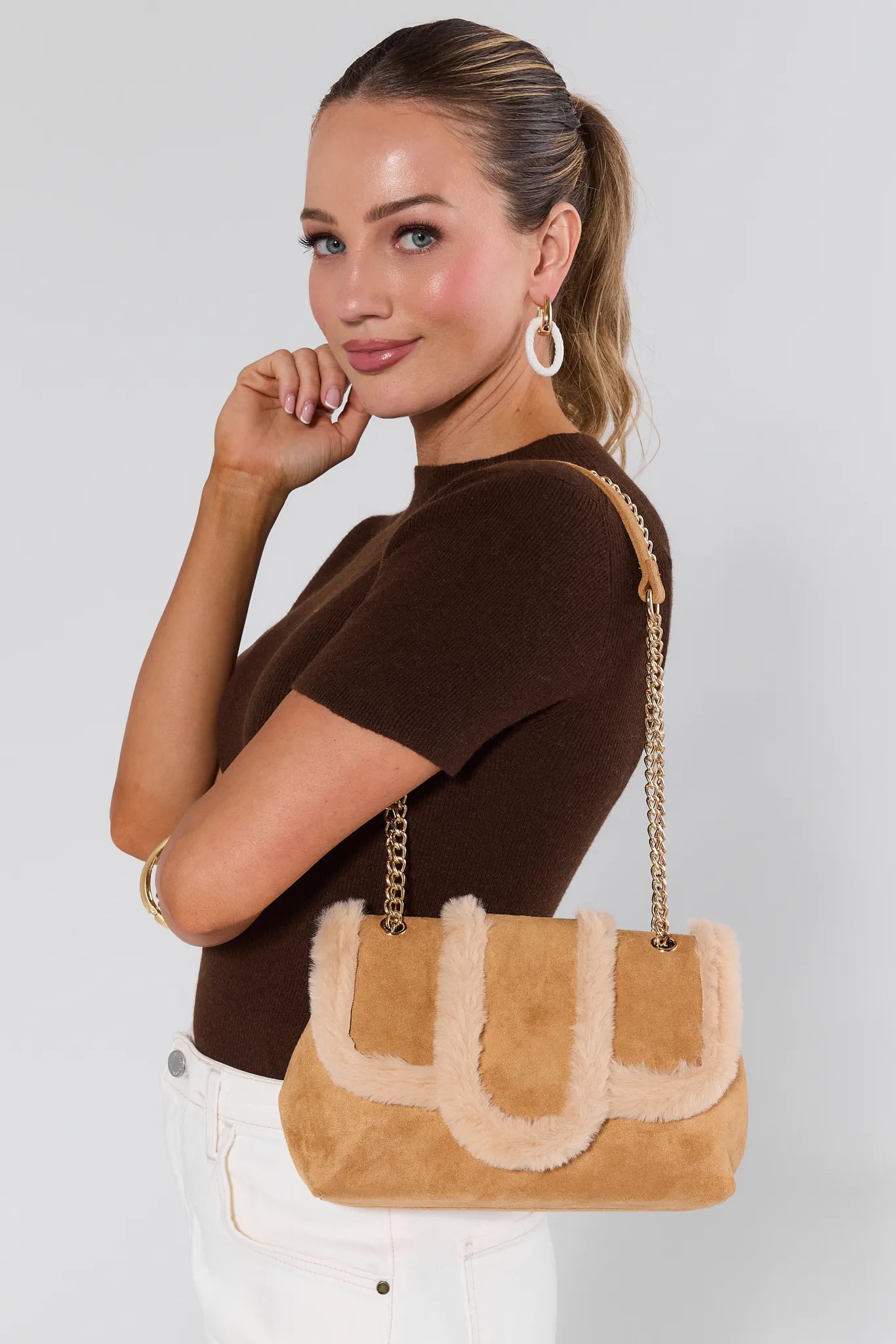 Woman holding a tan handbag with a gold chain strap against a white background Tori Tan Suede Shoulder Bag