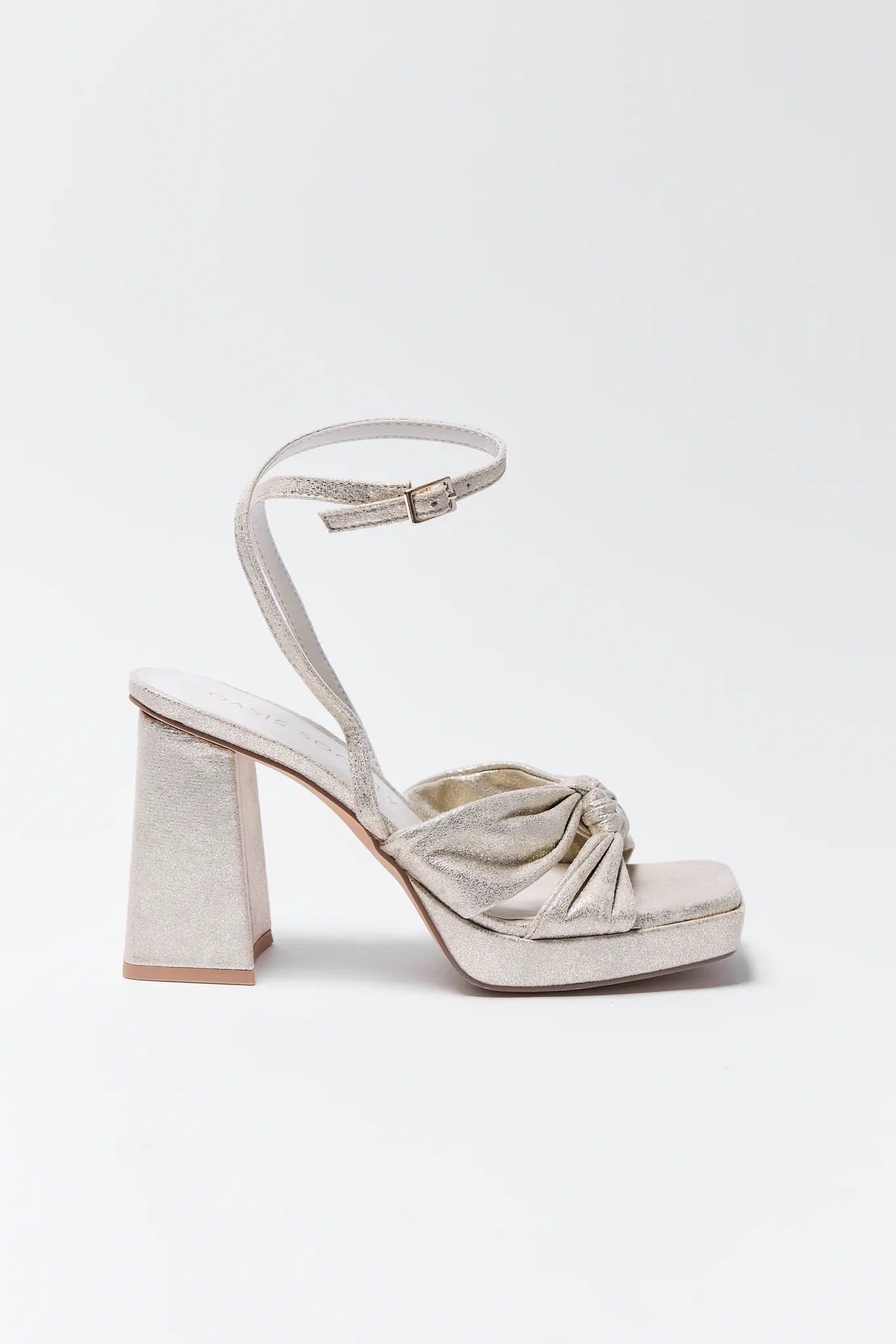 Pair of Zoey Gold Platform Heels with bow details on a white background