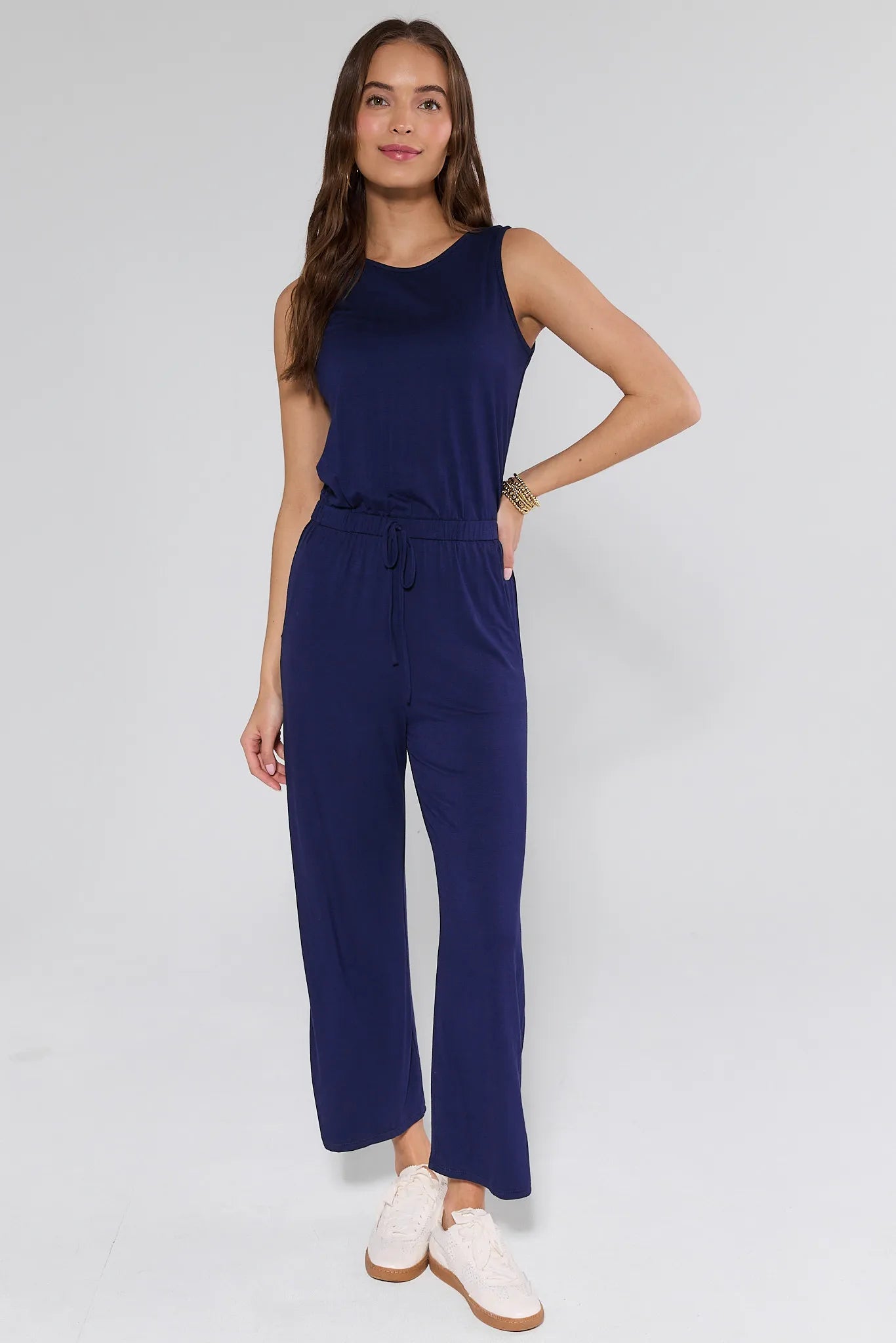 Woman wearing a navy blue jumpsuit on a white background