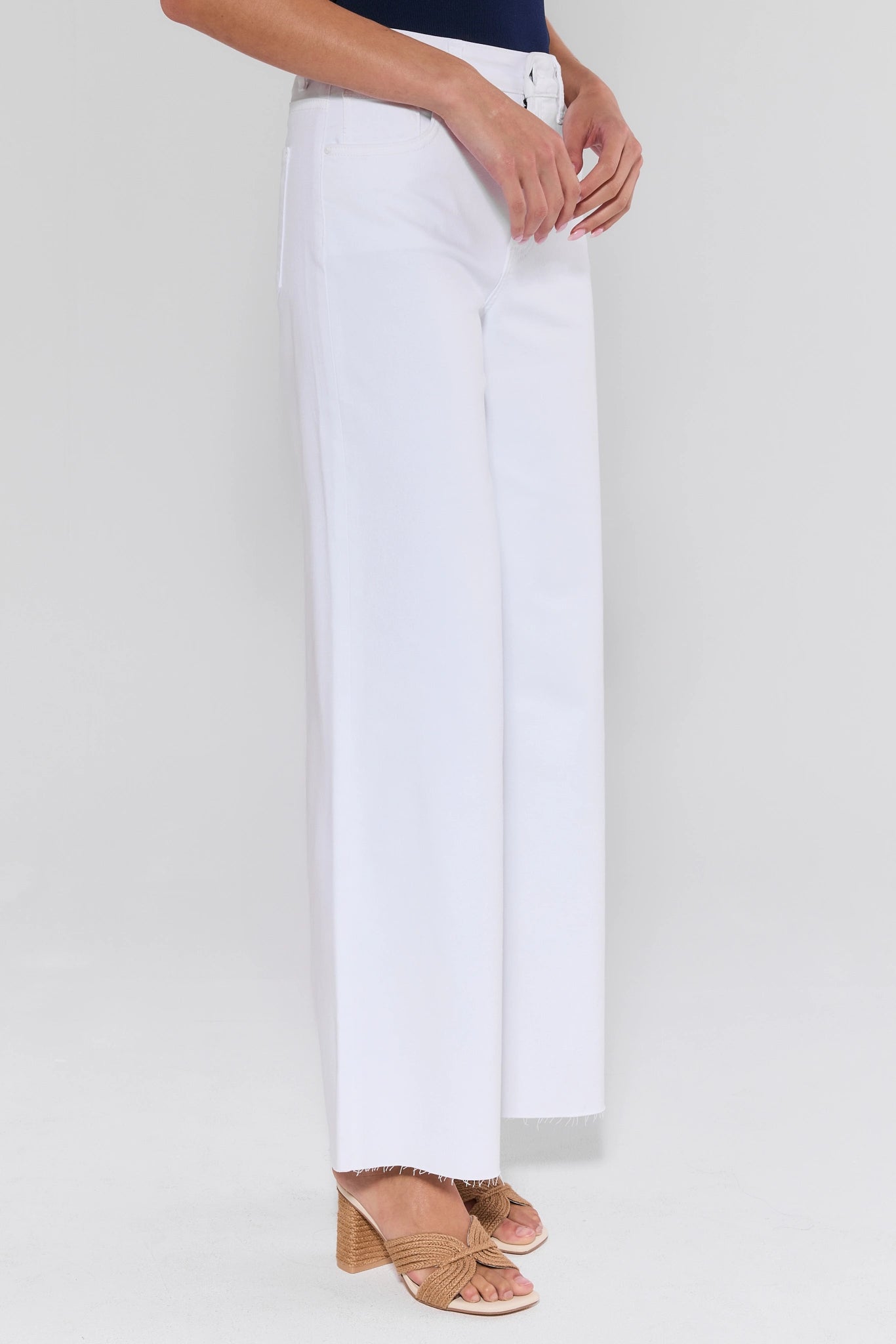 White pants worn by a person on a white background