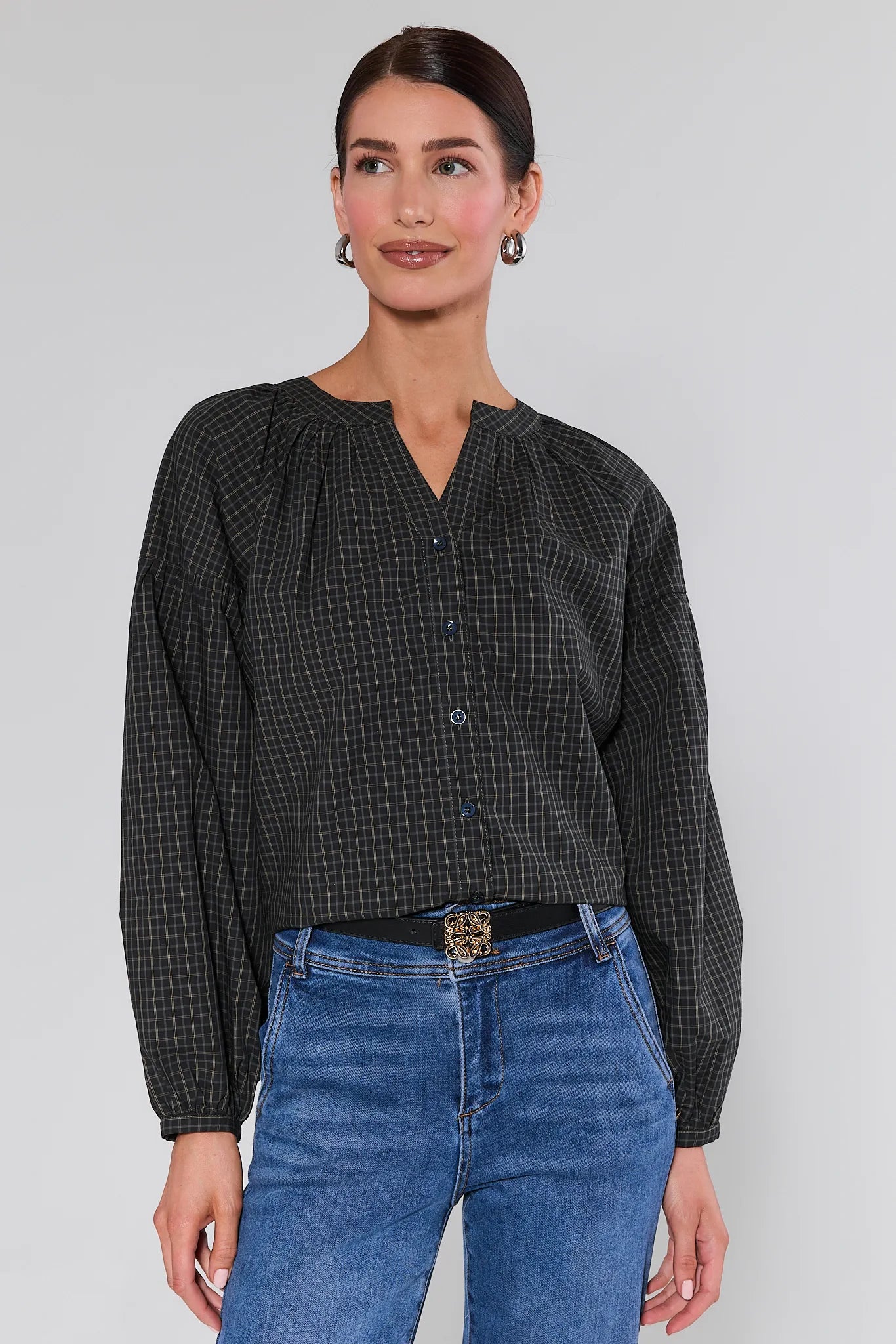Woman wearing a Sammy Plaid Button Up Top and blue jeans against a plain background
