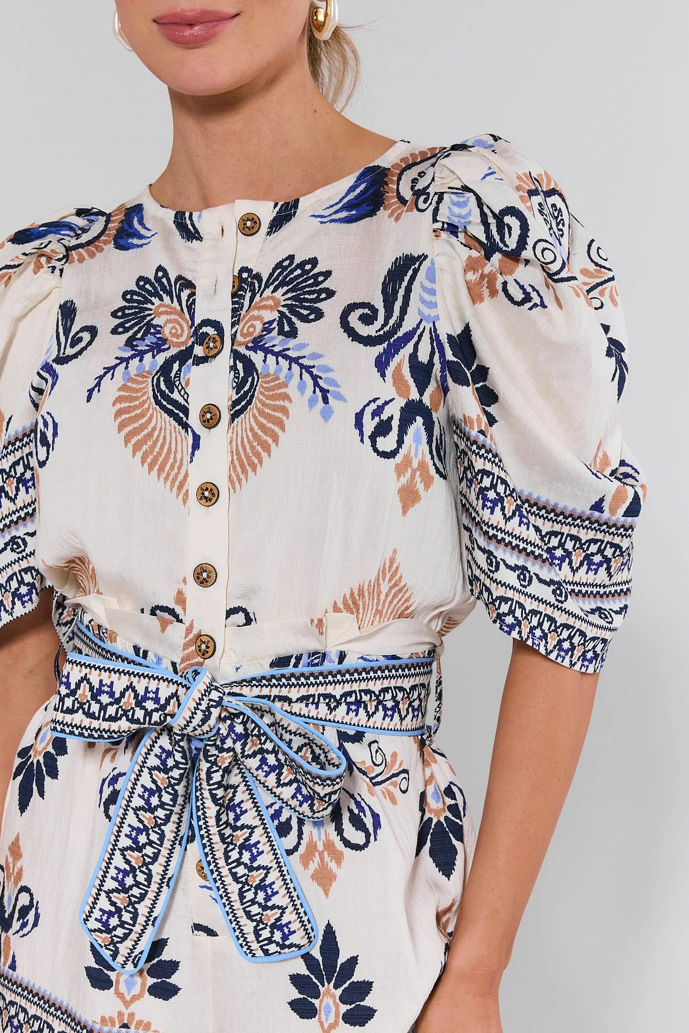 Woman wearing a patterned dress with a white background