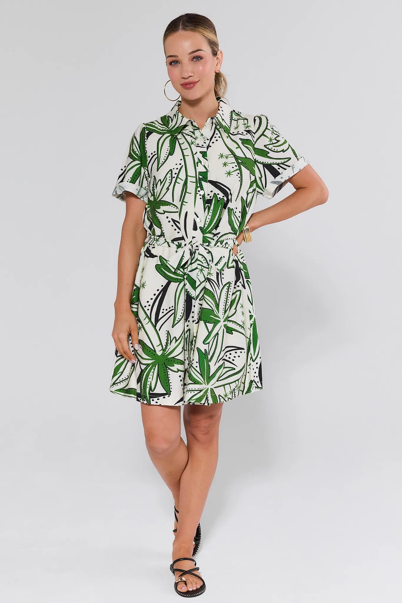 Woman wearing a green and white patterned dress on a white background