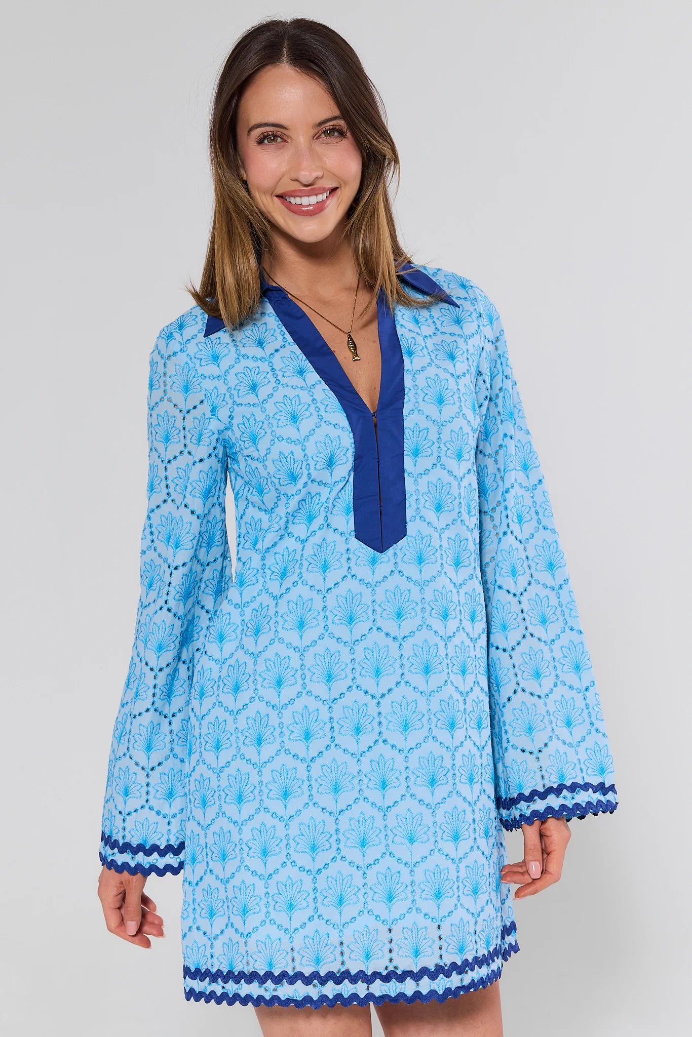 Woman wearing a blue patterned dress with a white background