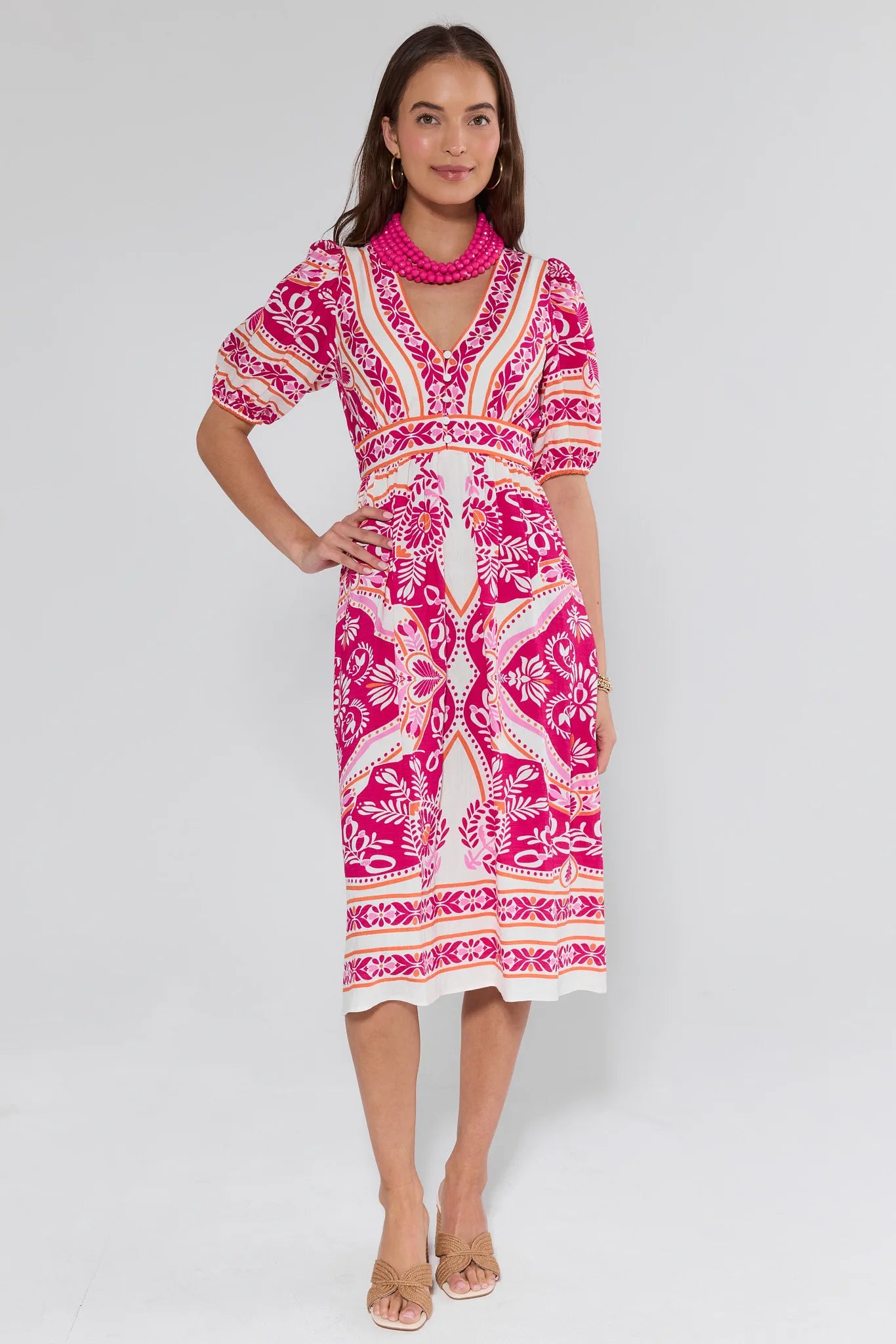 Woman wearing a pink and white patterned dress on a white background