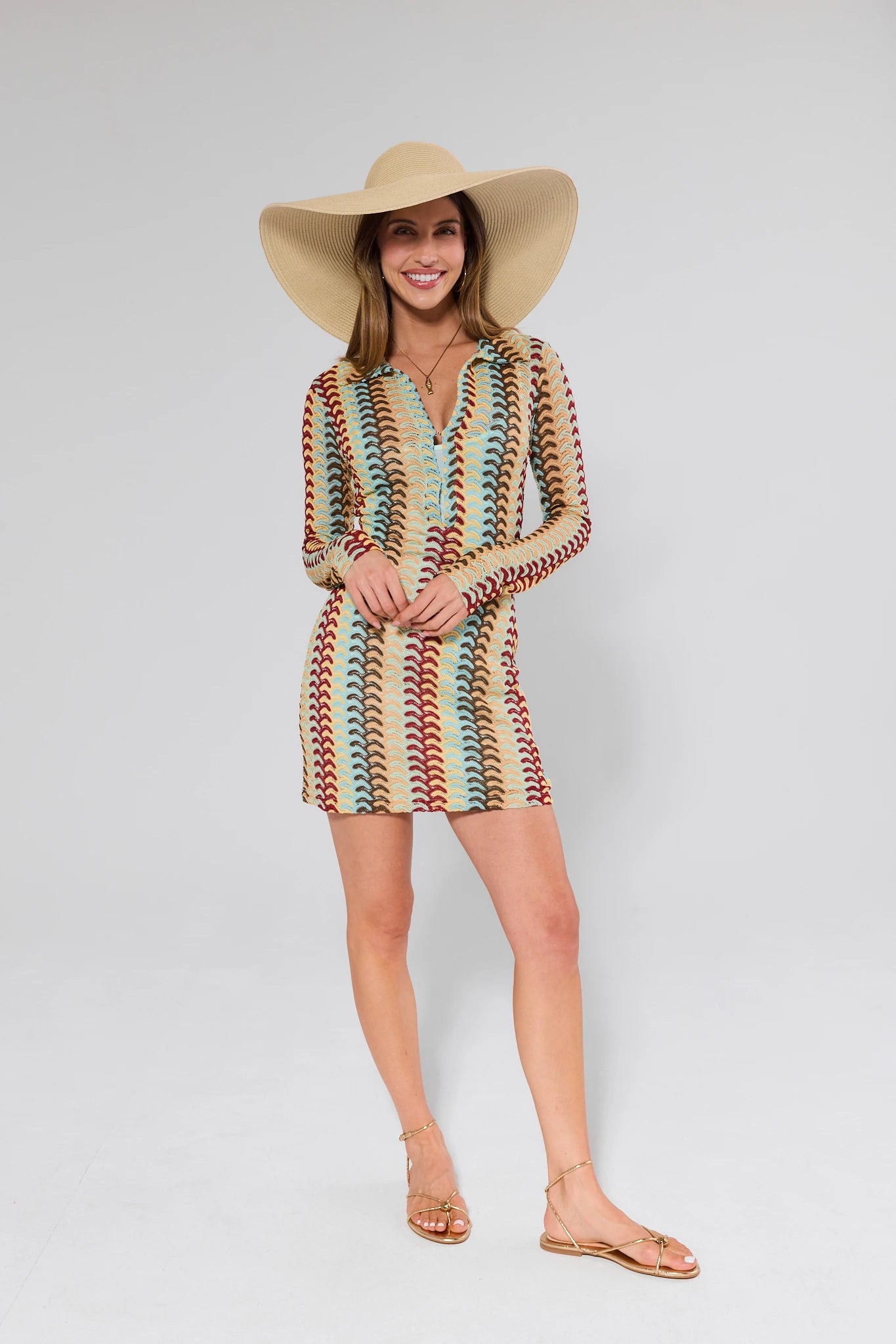 women wearing multicolor knit dress and tan hat on plain background
