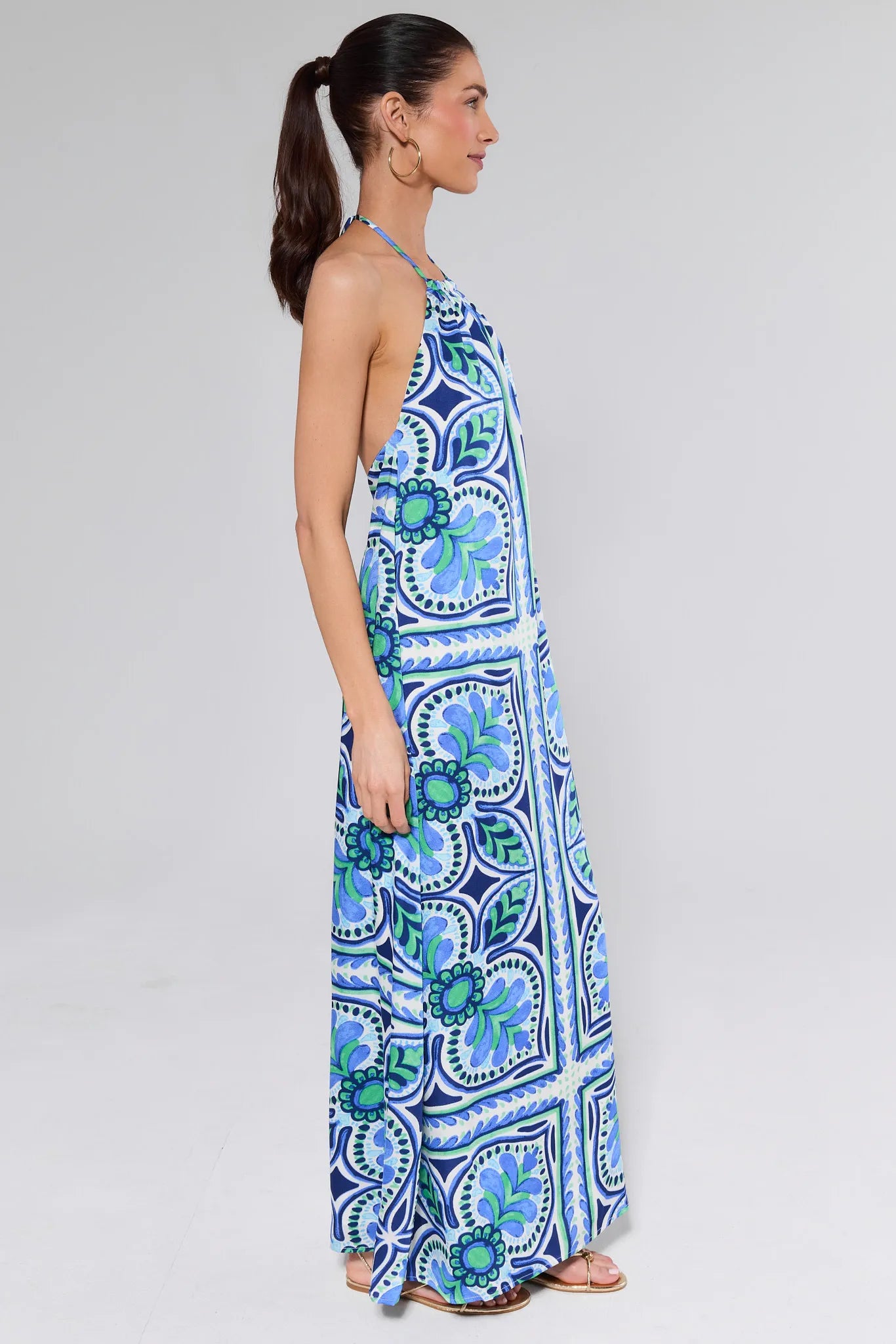 Woman wearing a blue and green patterned dress on a white background