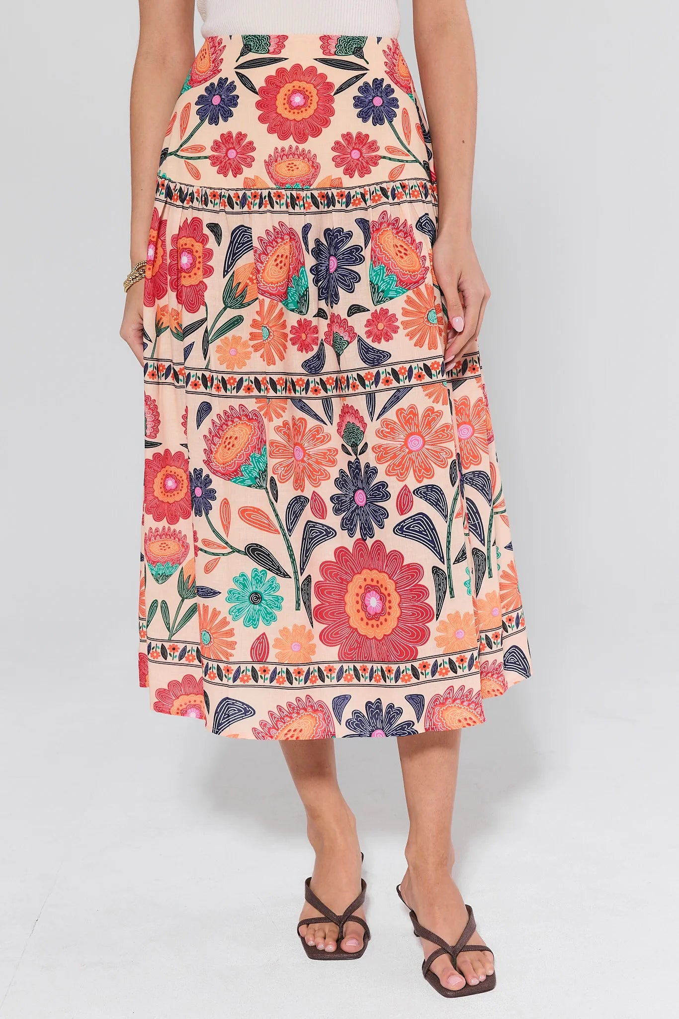 Person wearing a colorful floral skirt on a white background
