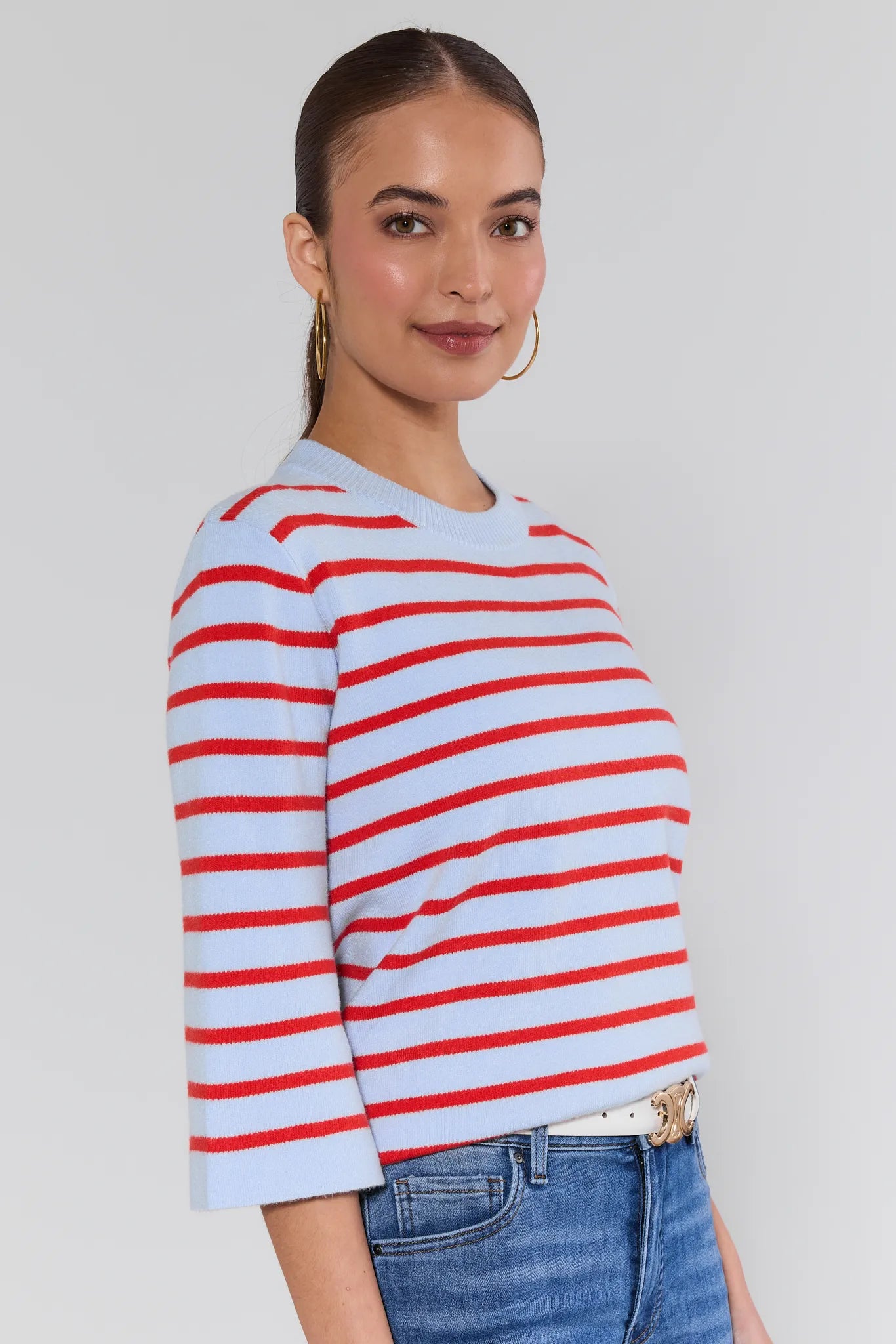 Woman wearing a red and white striped sweater with a plain background