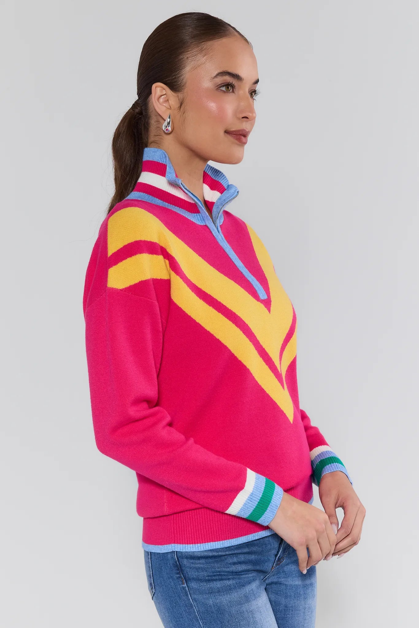 Woman wearing a colorful striped sweater with a white background