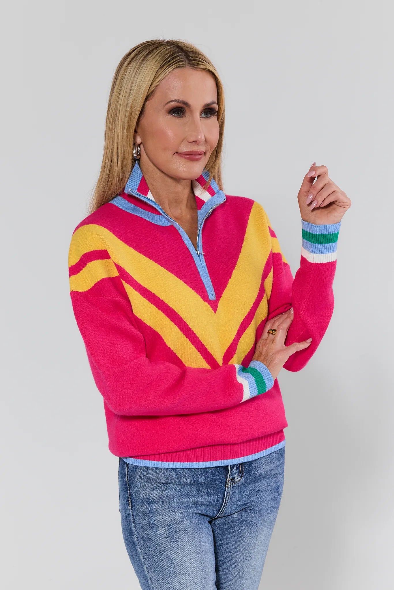 Woman wearing a colorful striped sweater with a plain background