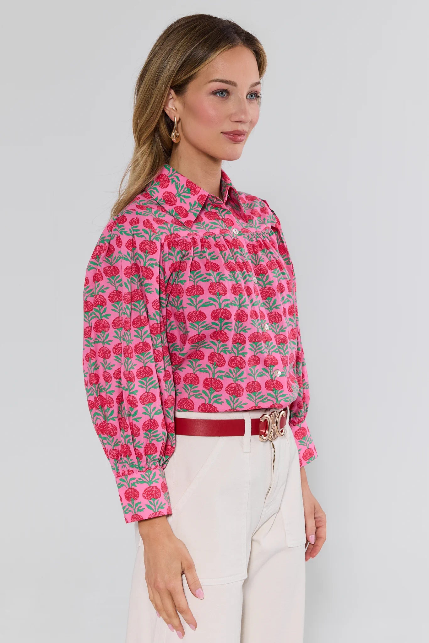 Woman wearing a pink floral patterned shirt with a white background
