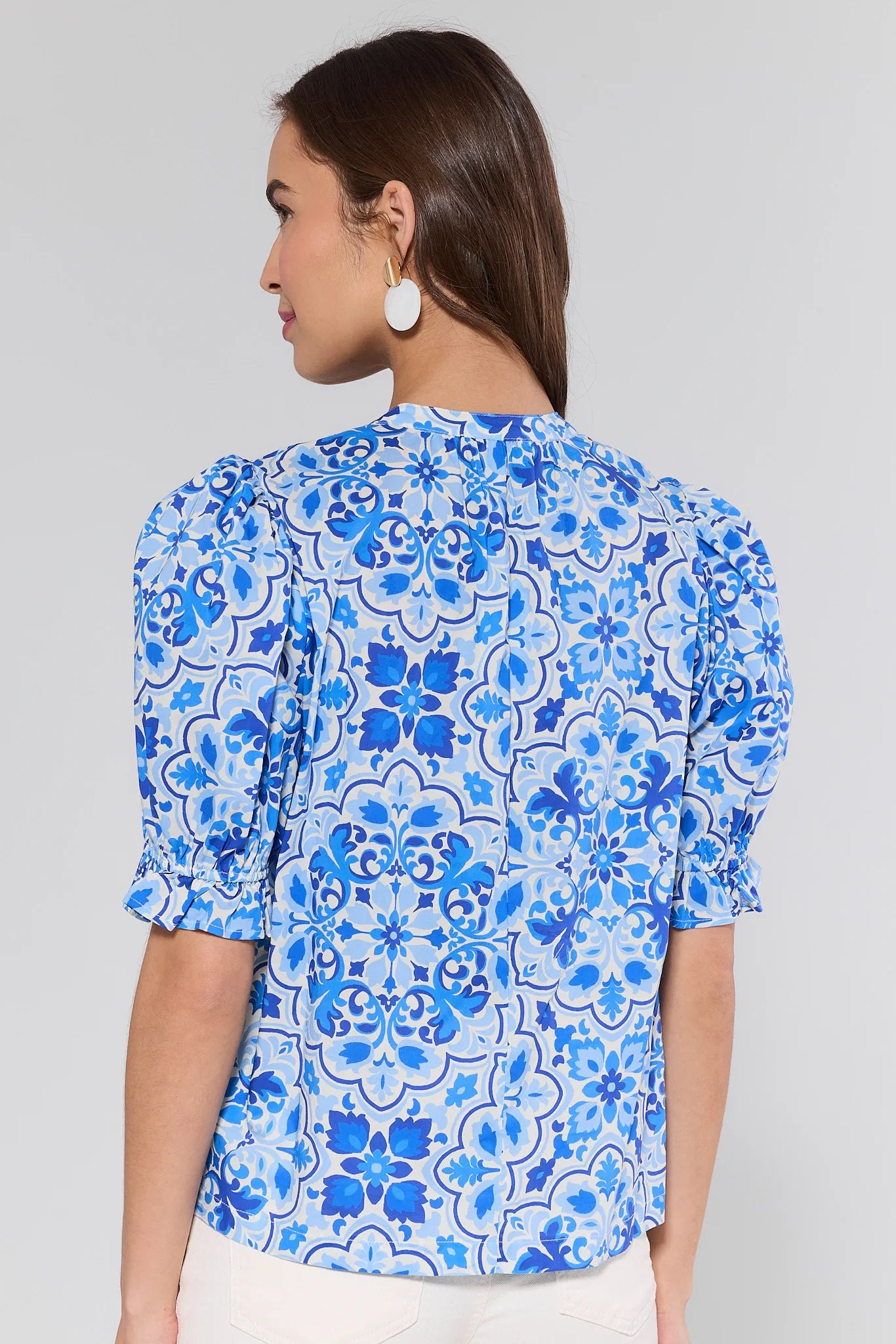 Woman wearing a blue floral blouse against a gray background