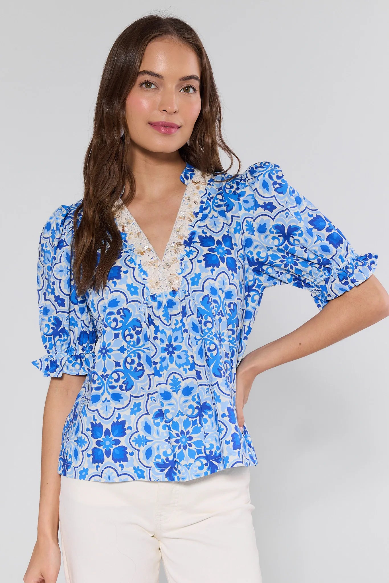 Woman wearing a blue floral blouse with a white background